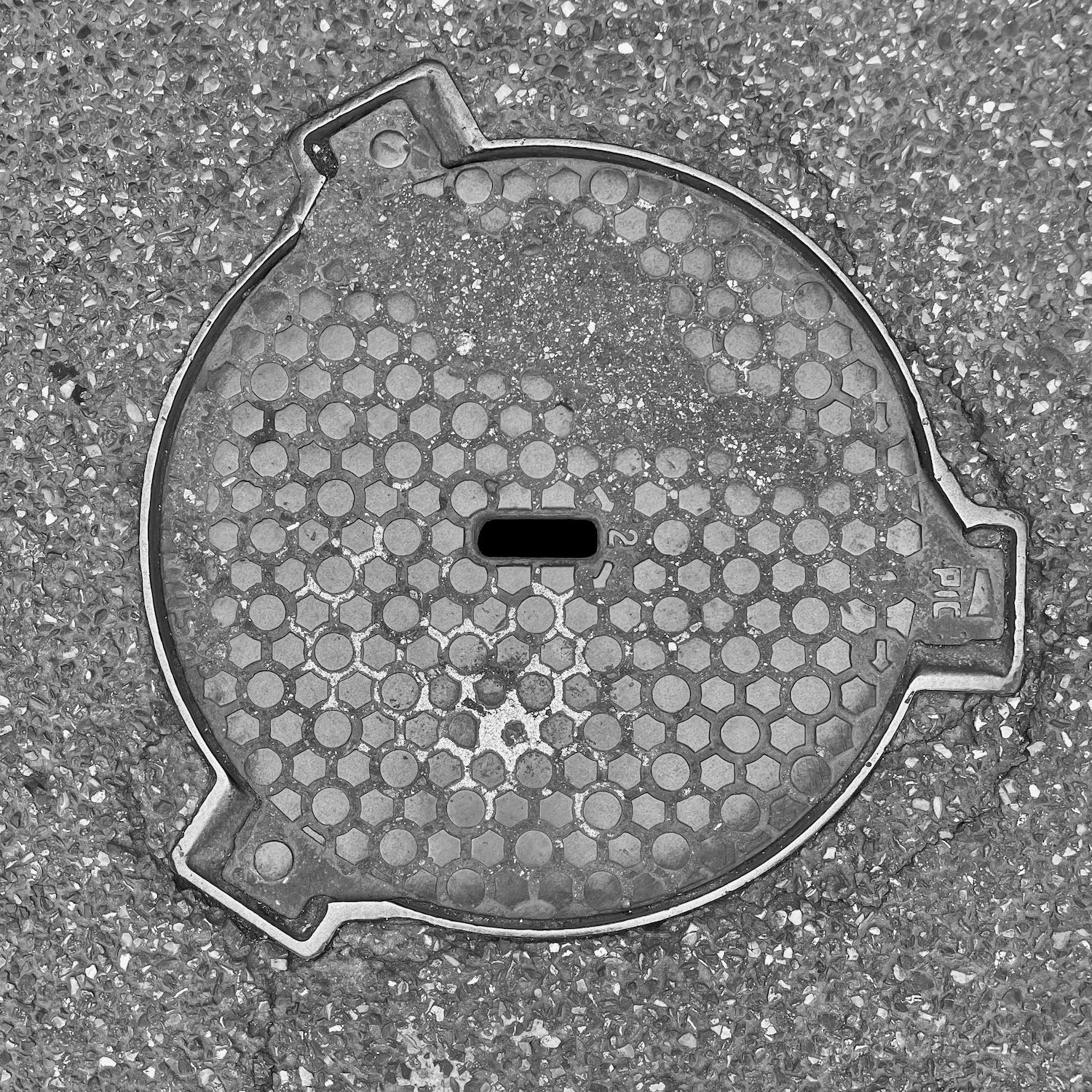 black and white image of a utility cover