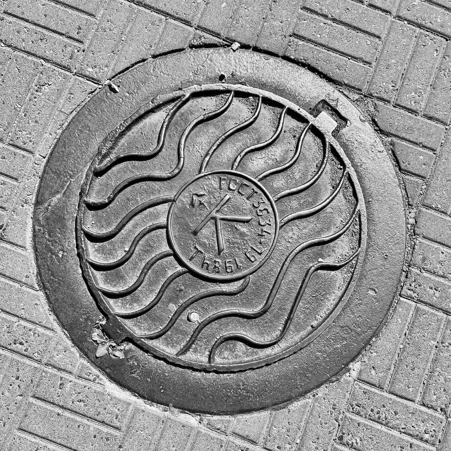 black and white image of a utility cover