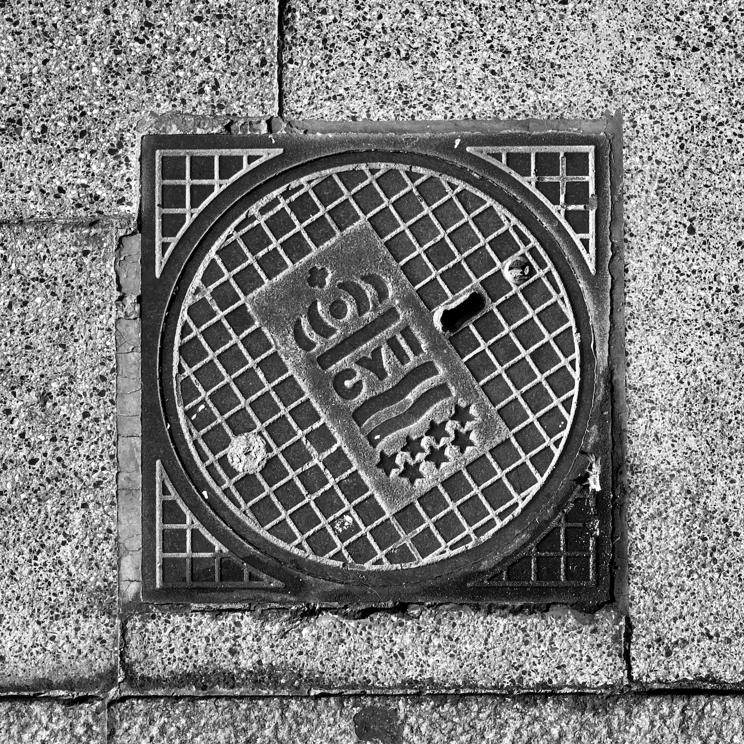 black and white image of a utility cover