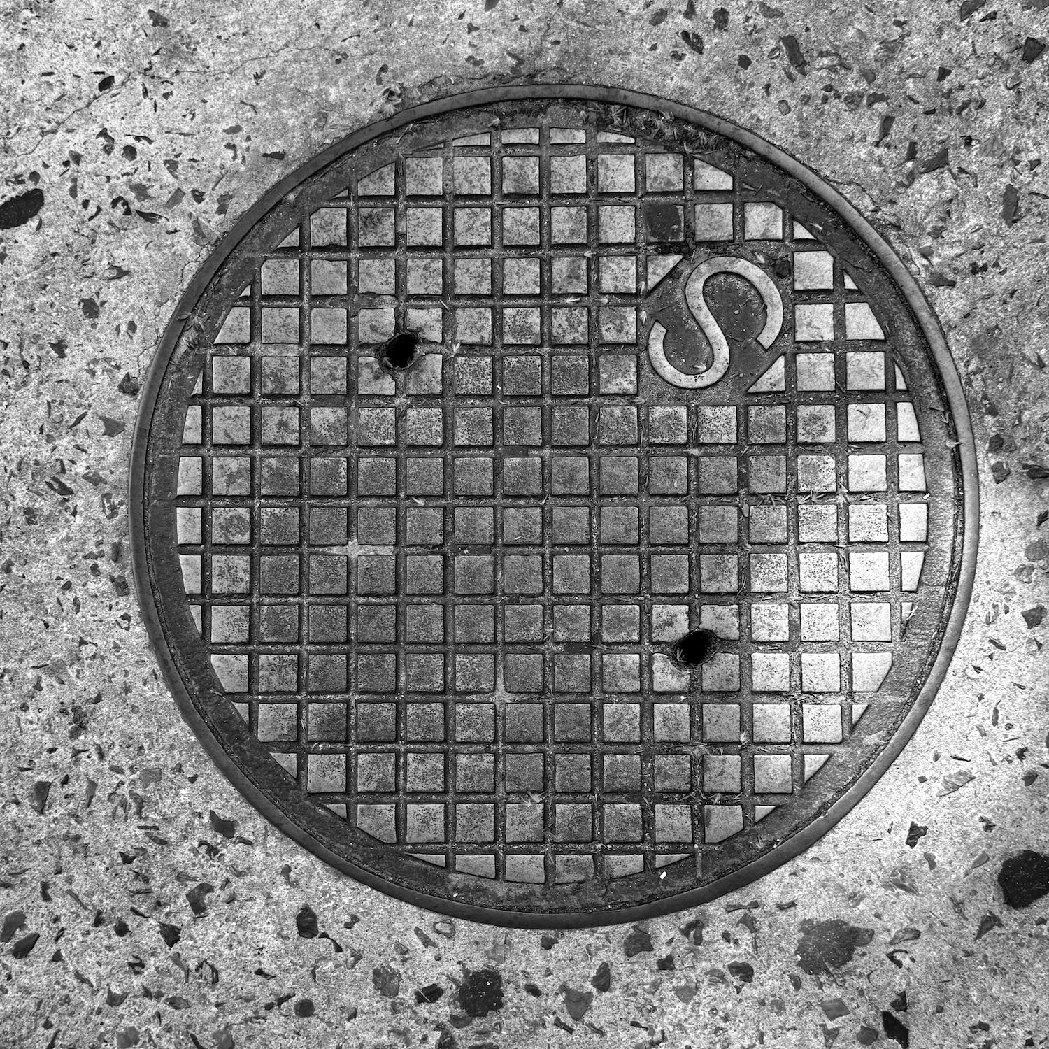 black and white image of a utility cover