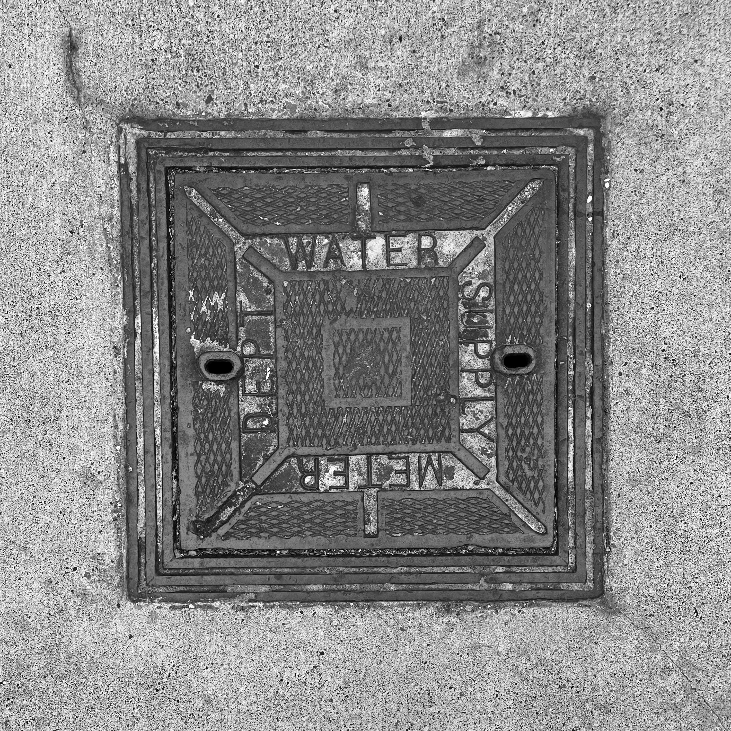 black and white image of a utility cover