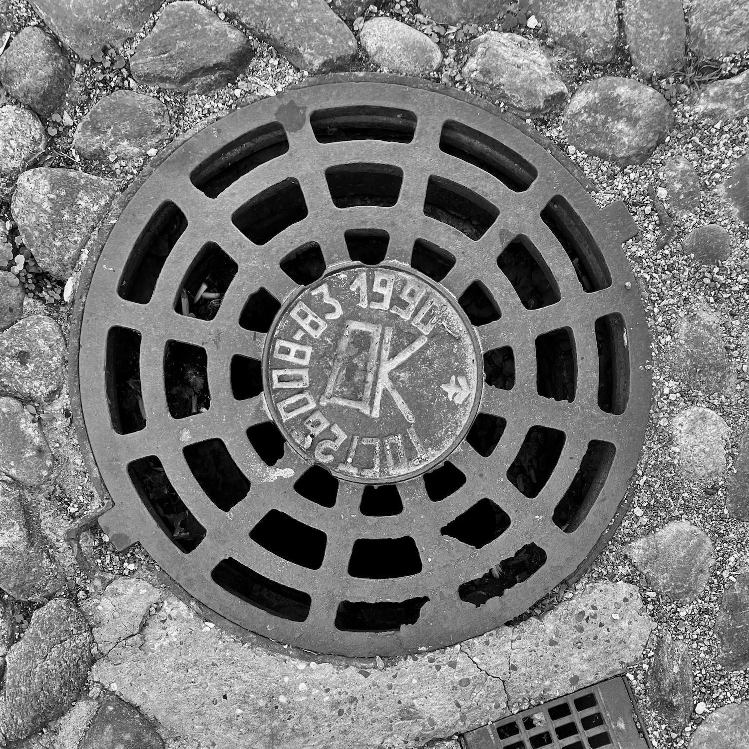 black and white image of a utility cover