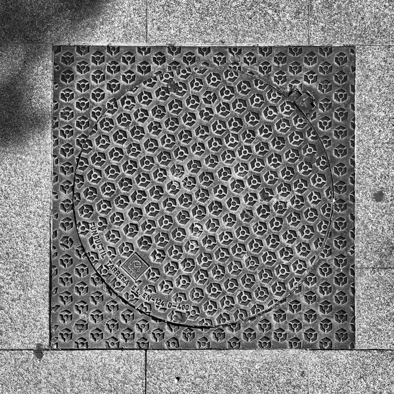 black and white image of a utility cover