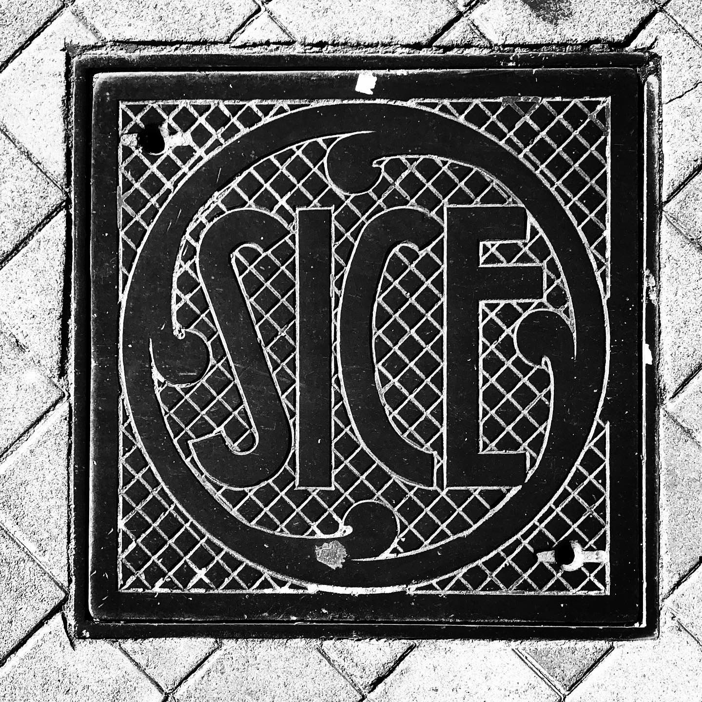 black and white image of a utility cover