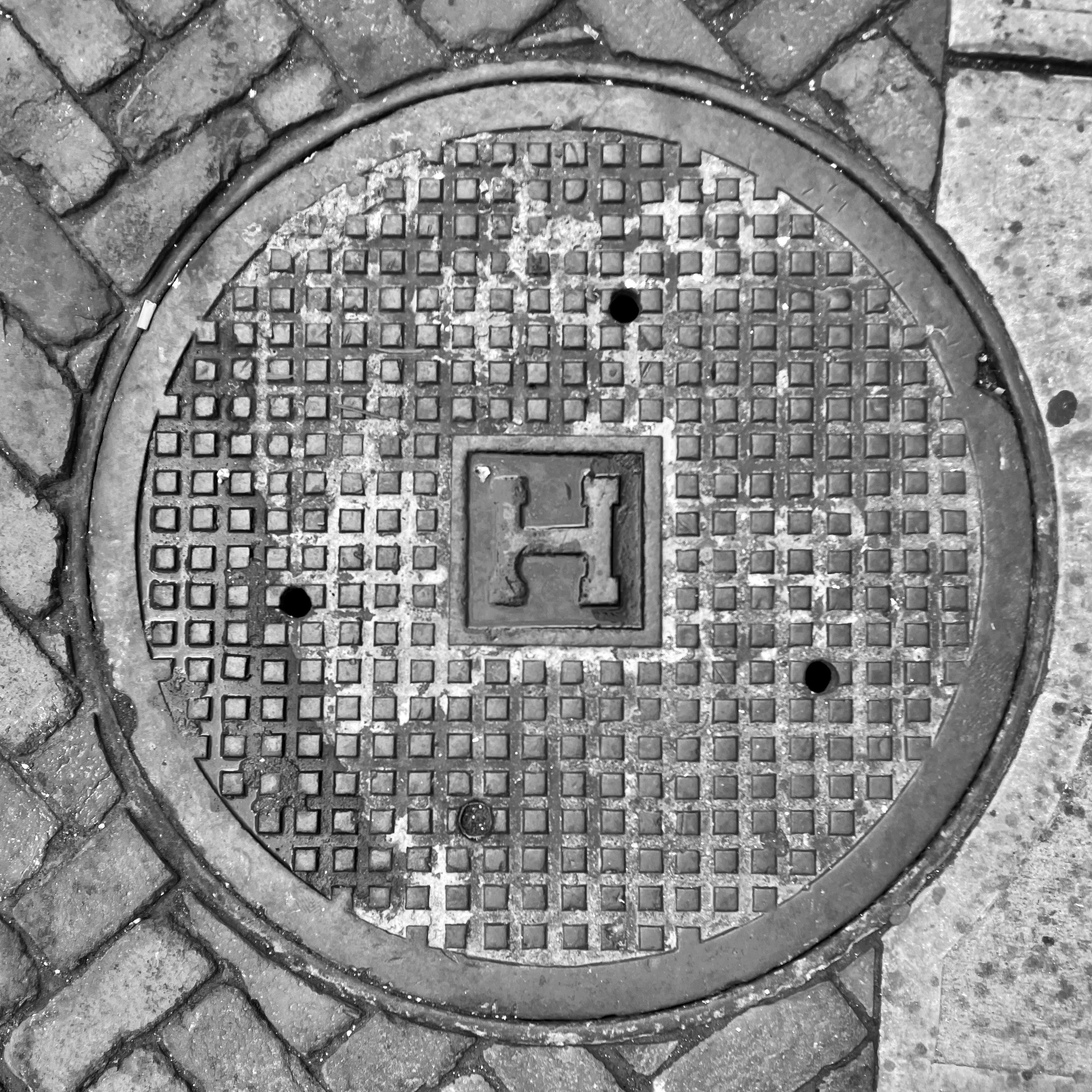 black and white image of a utility cover