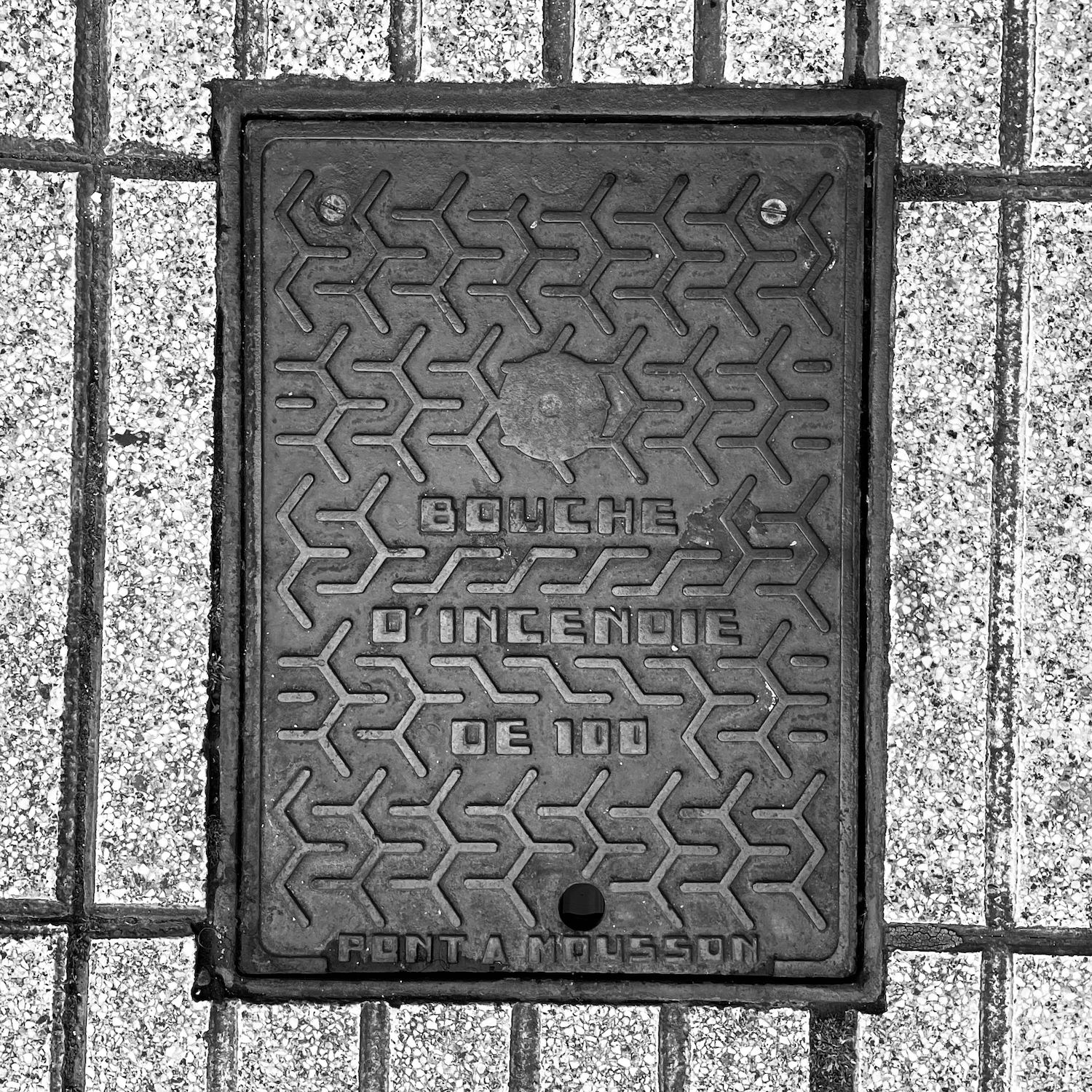 black and white image of a utility cover