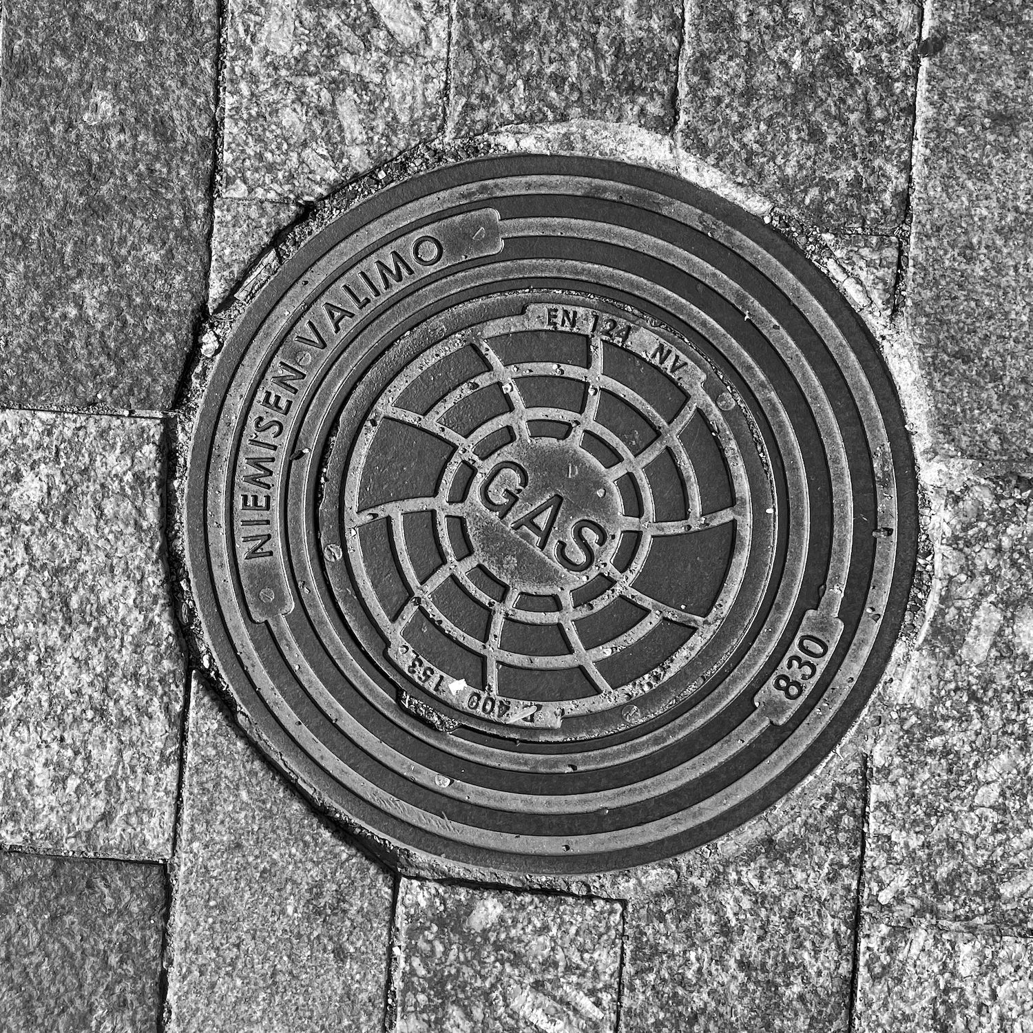black and white image of a utility cover