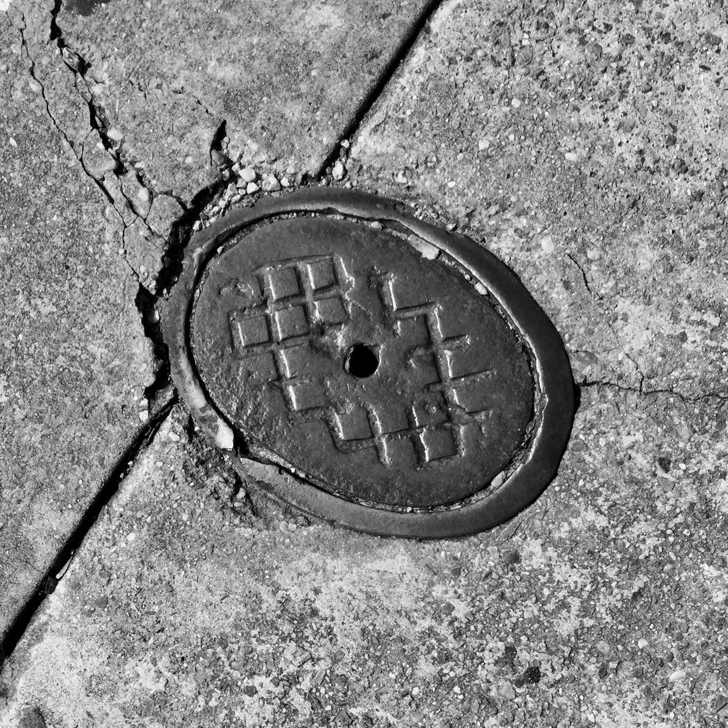 black and white image of a utility cover