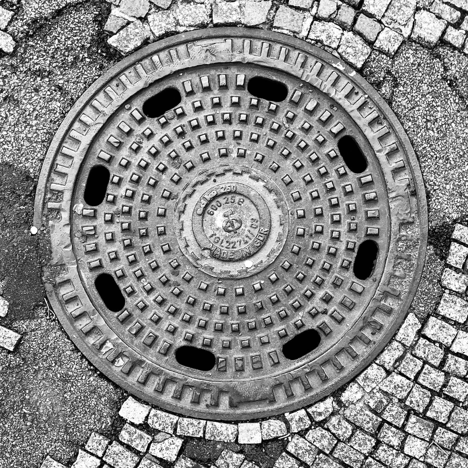black and white image of a utility cover