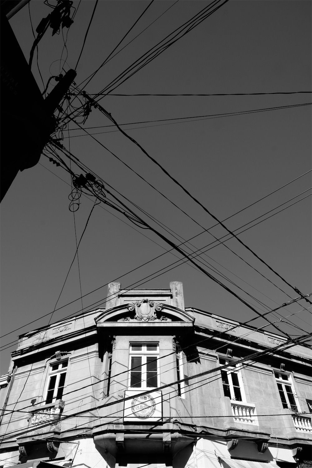 building with electrical wires in foreground in black and white