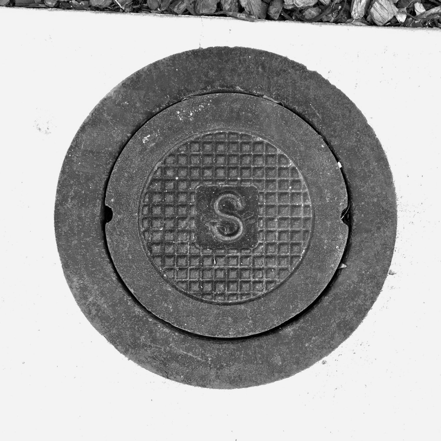 black and white image of a utility cover