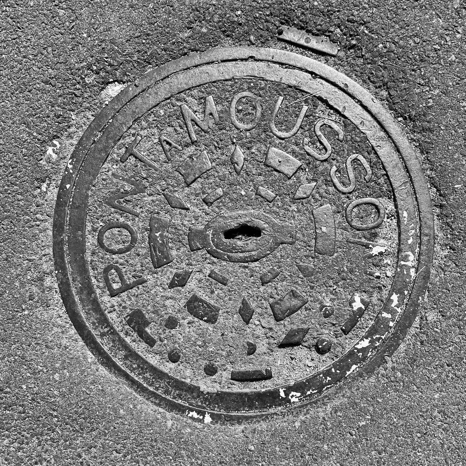 black and white image of a utility cover