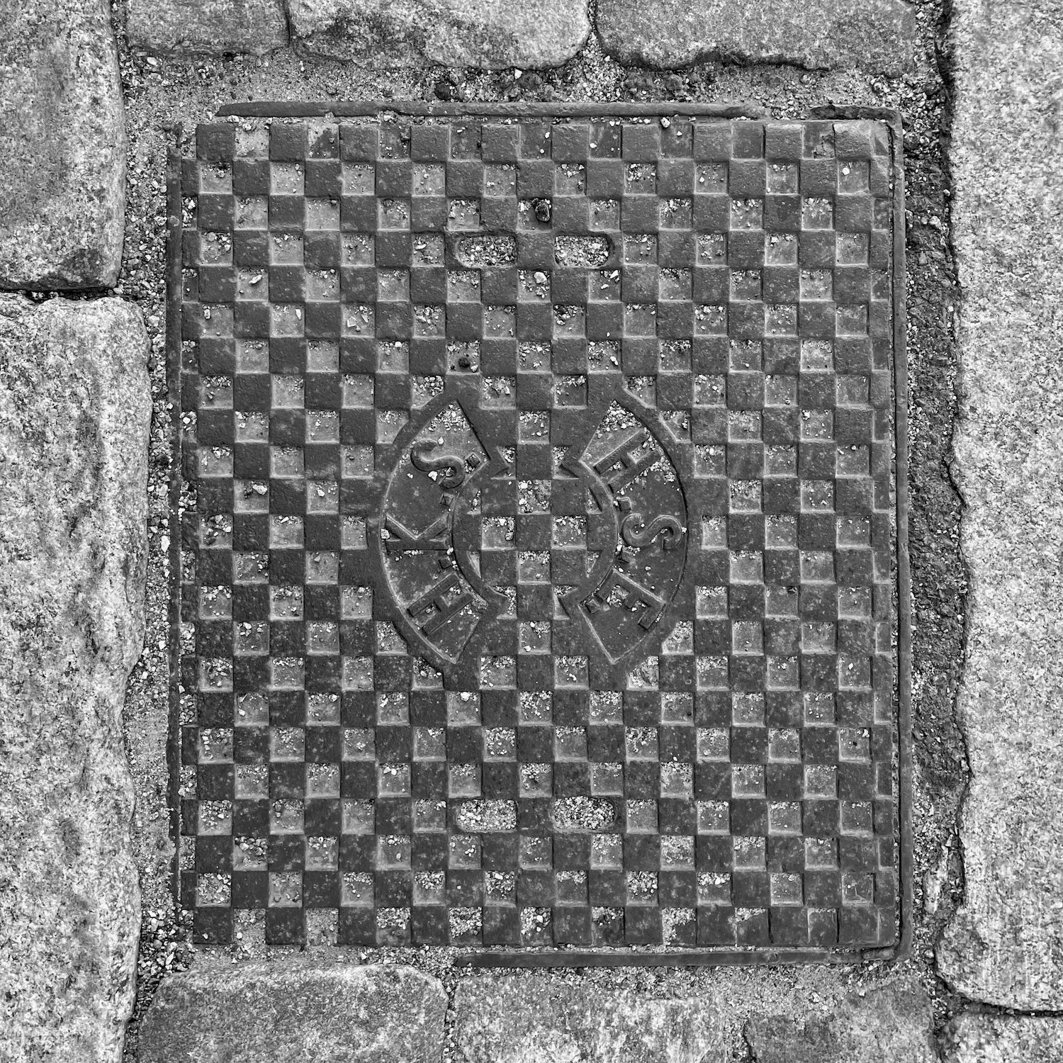 black and white image of a utility cover