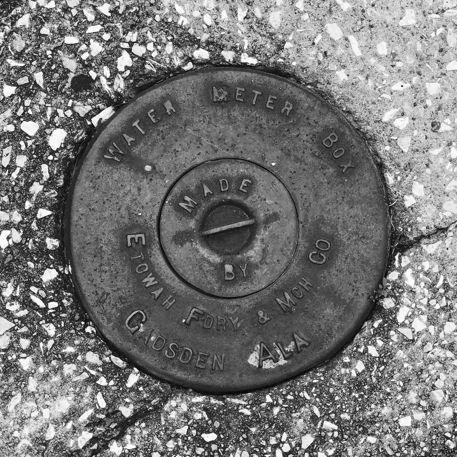 black and white image of a utility cover