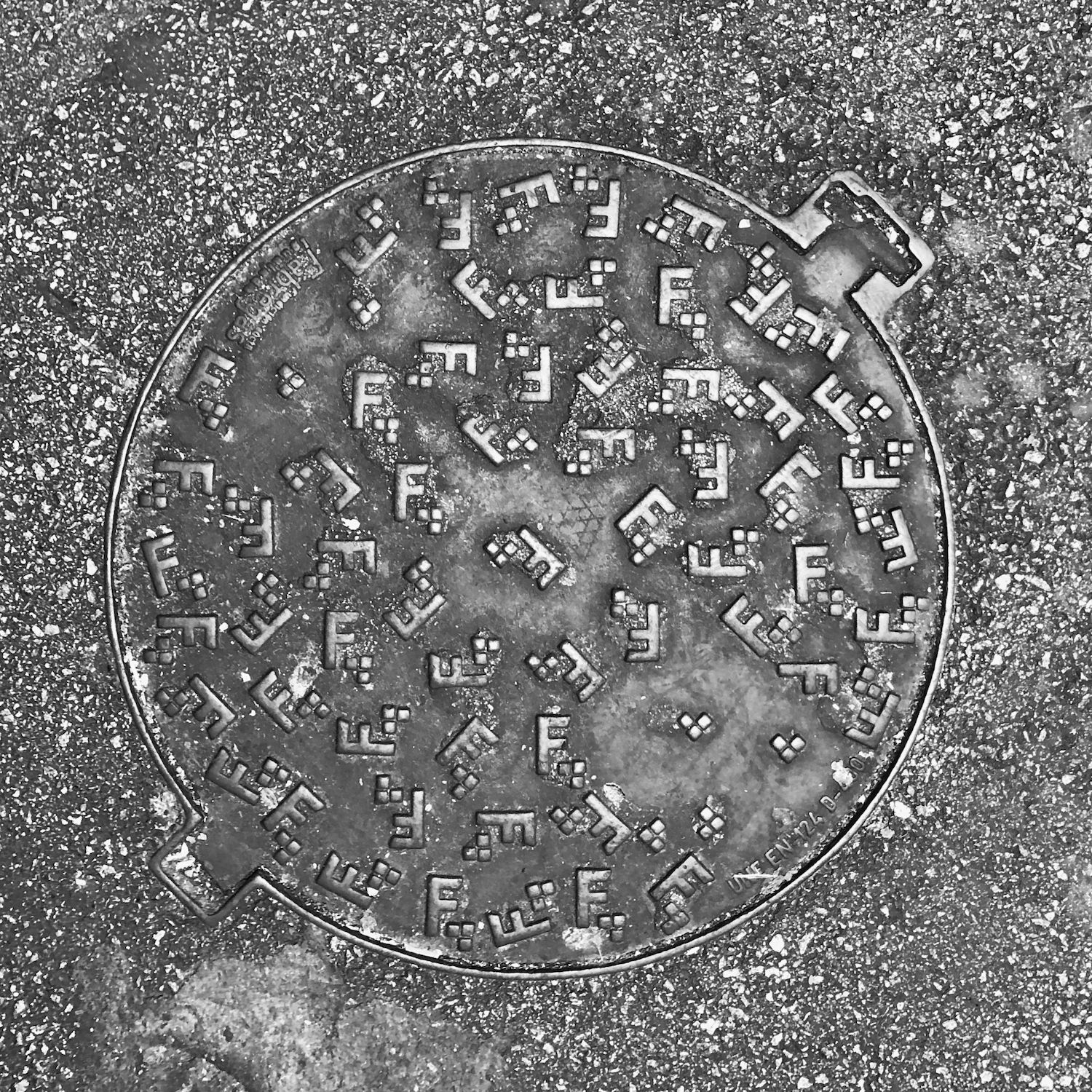 black and white image of a utility cover