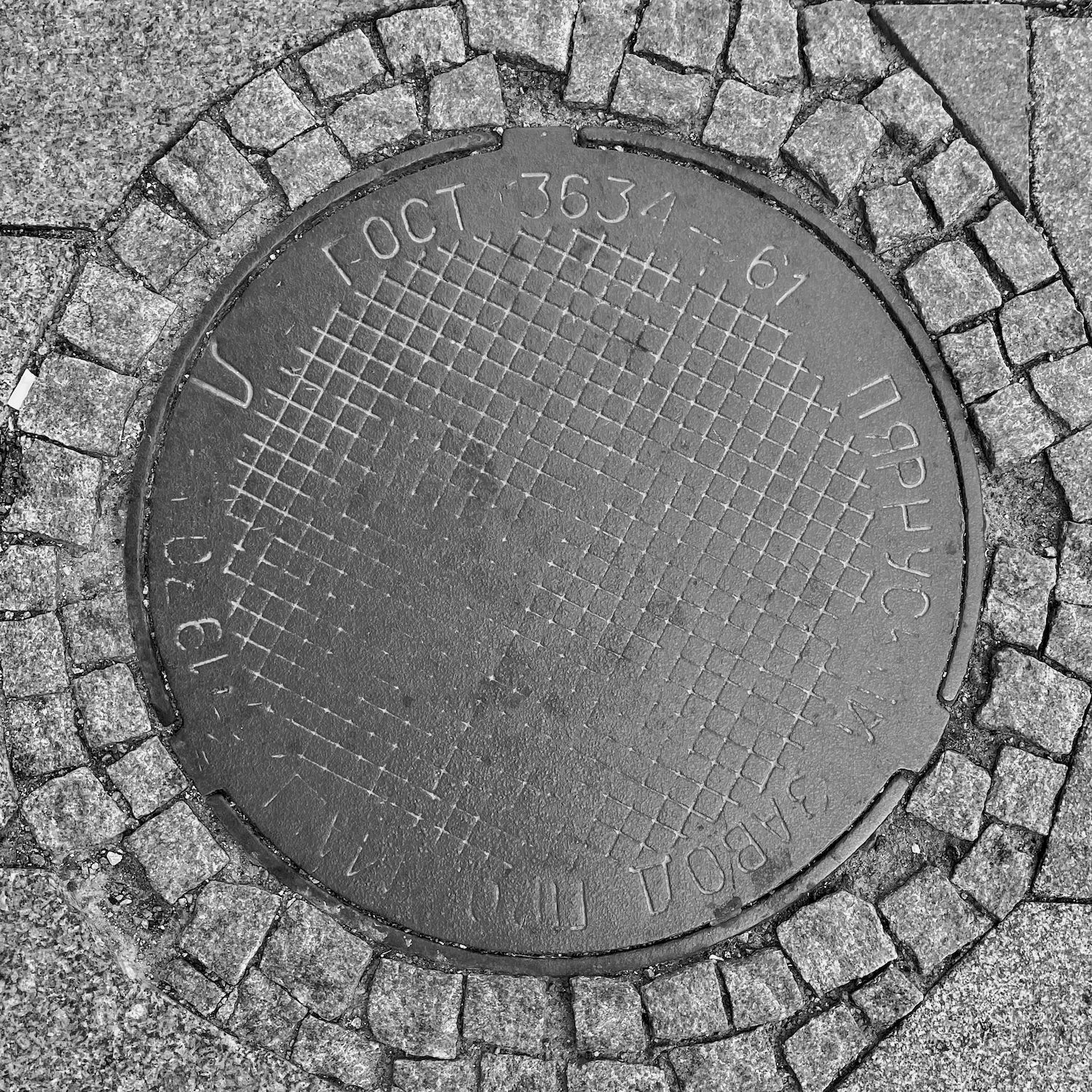 black and white image of a utility cover