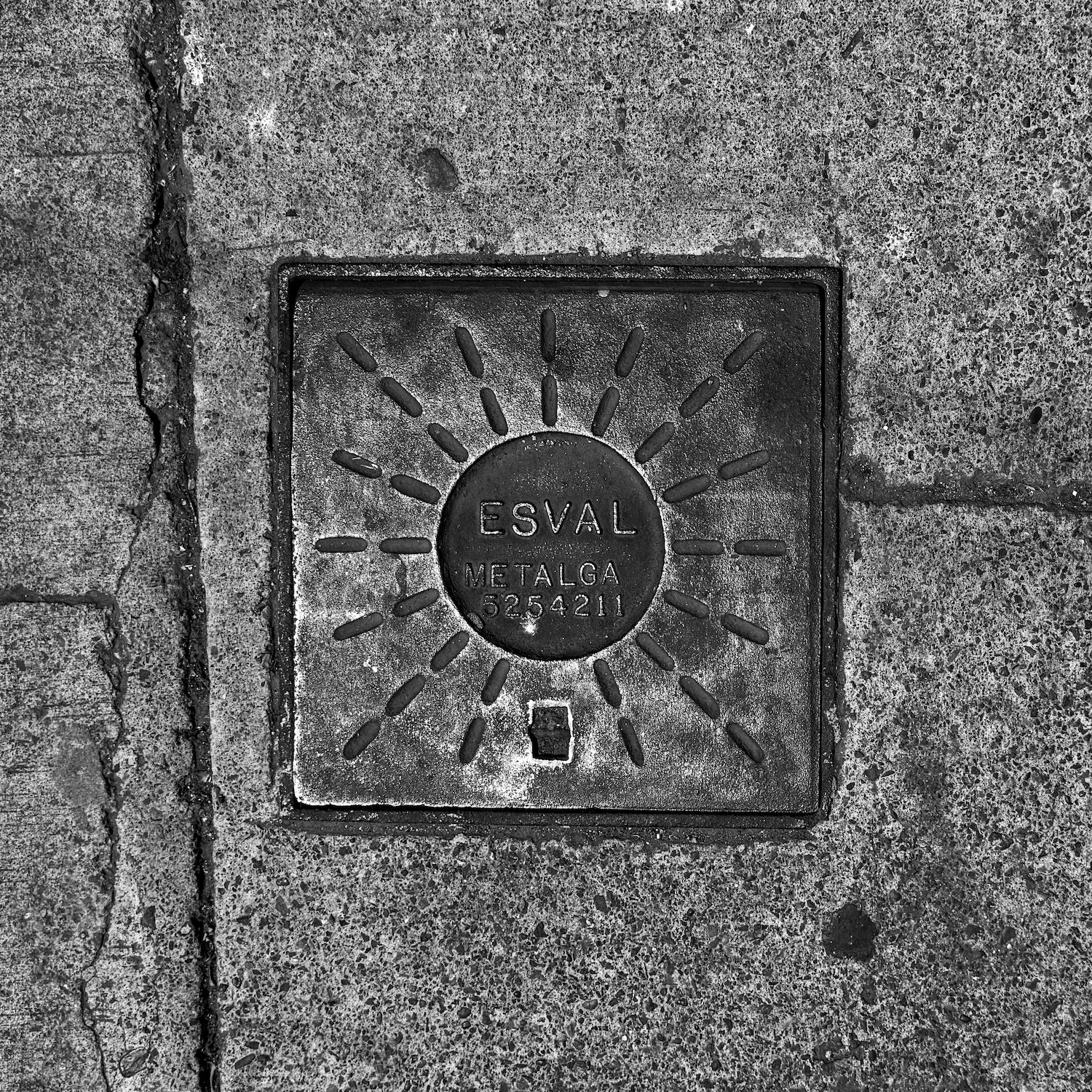 black and white image of a utility cover