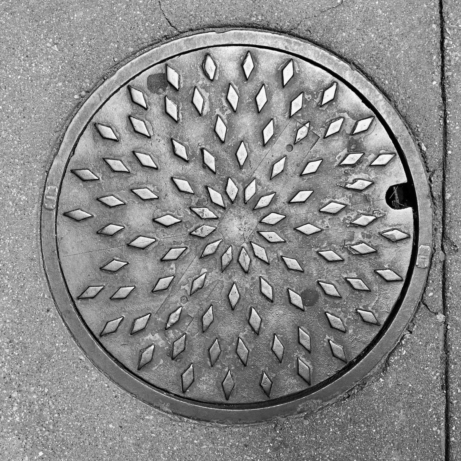 black and white image of a utility cover