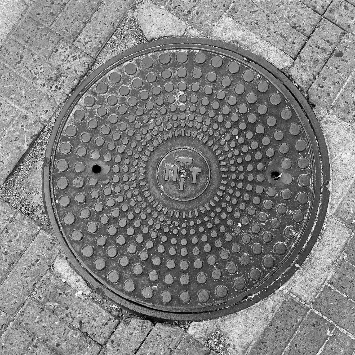 black and white image of a utility cover