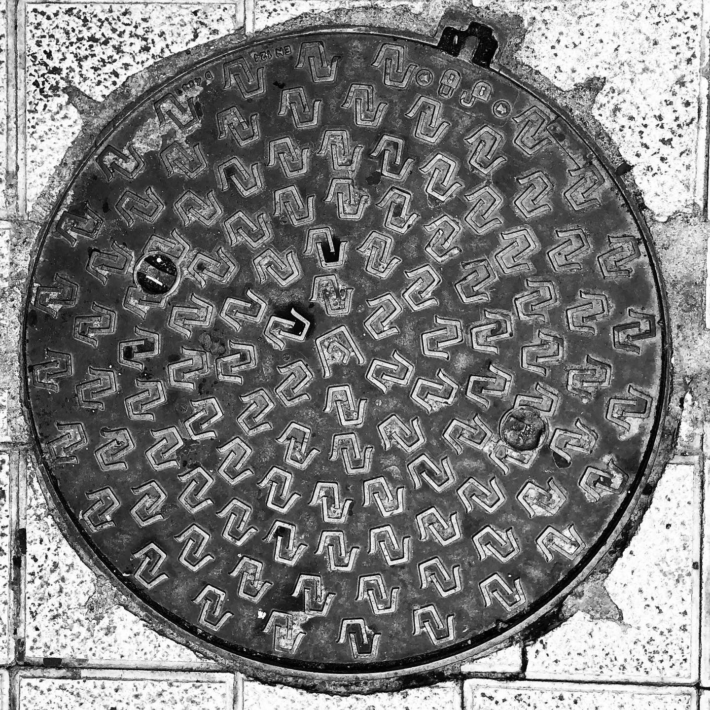 black and white image of a utility cover