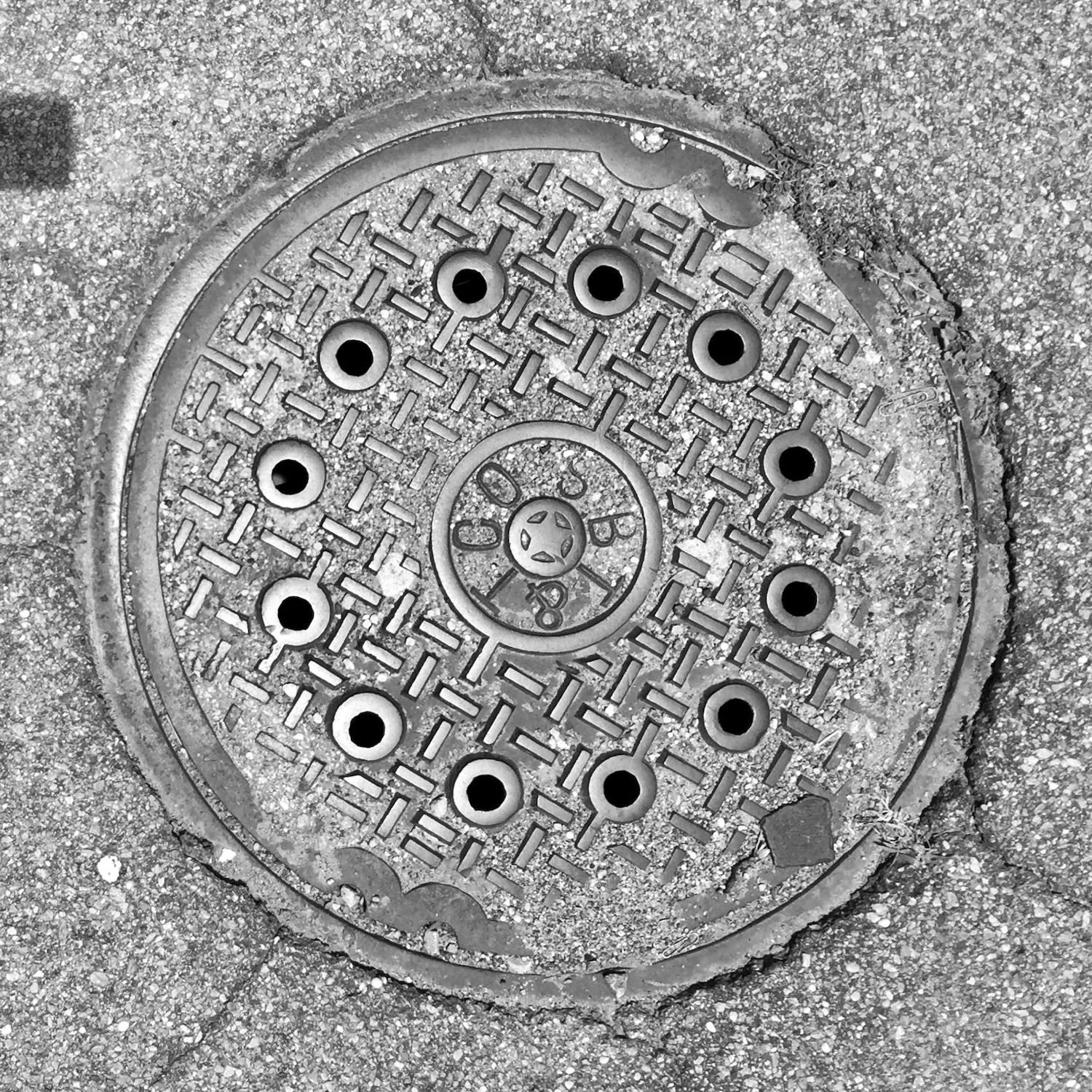 black and white image of a utility cover