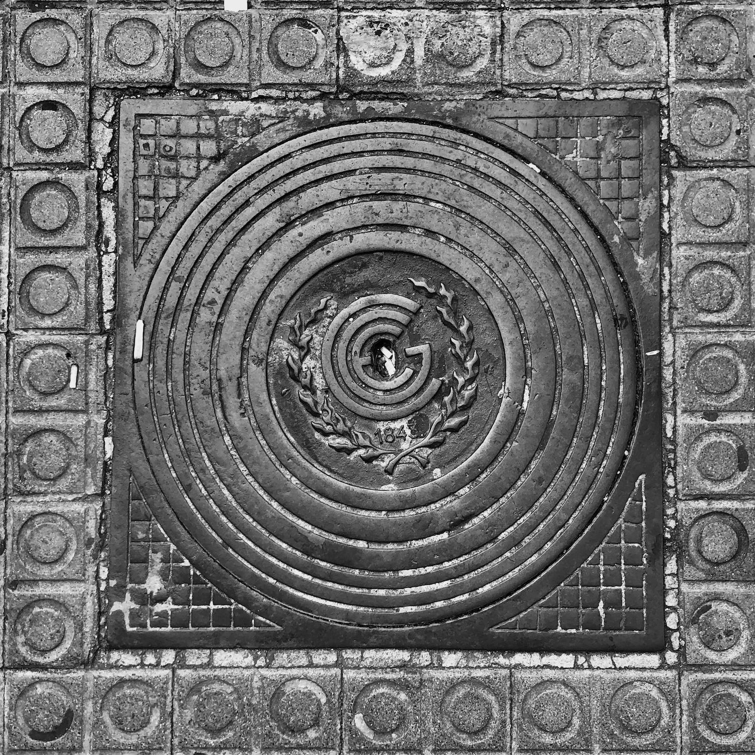 black and white image of a utility cover