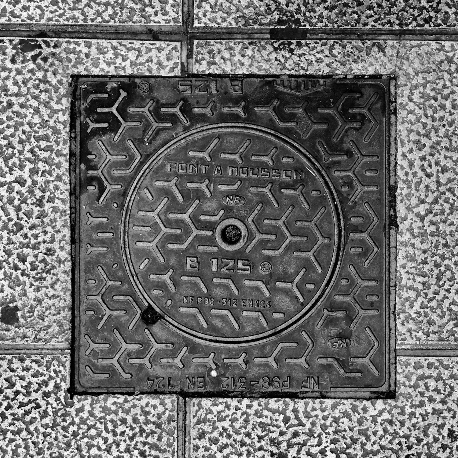 black and white image of a utility cover