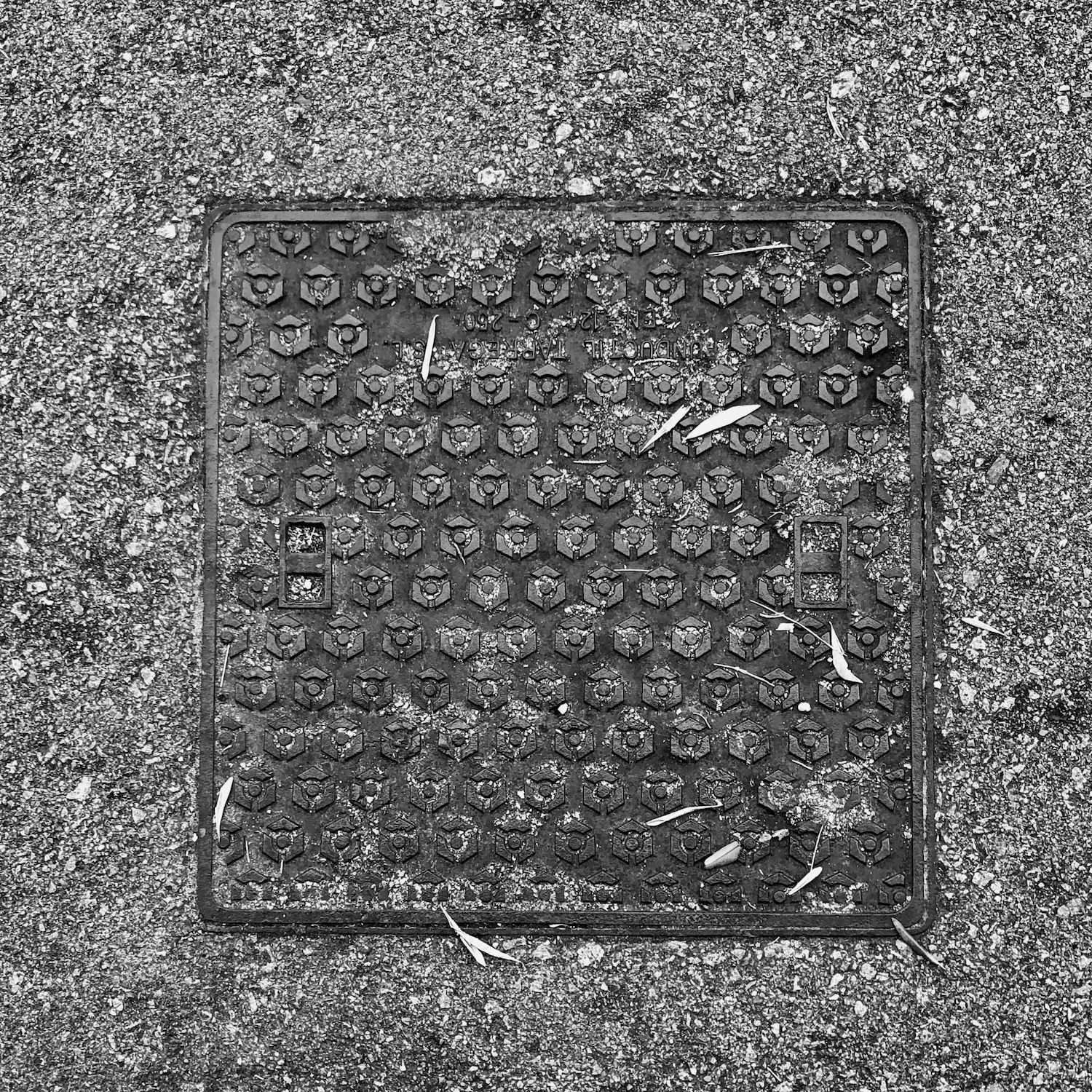 black and white image of a utility cover