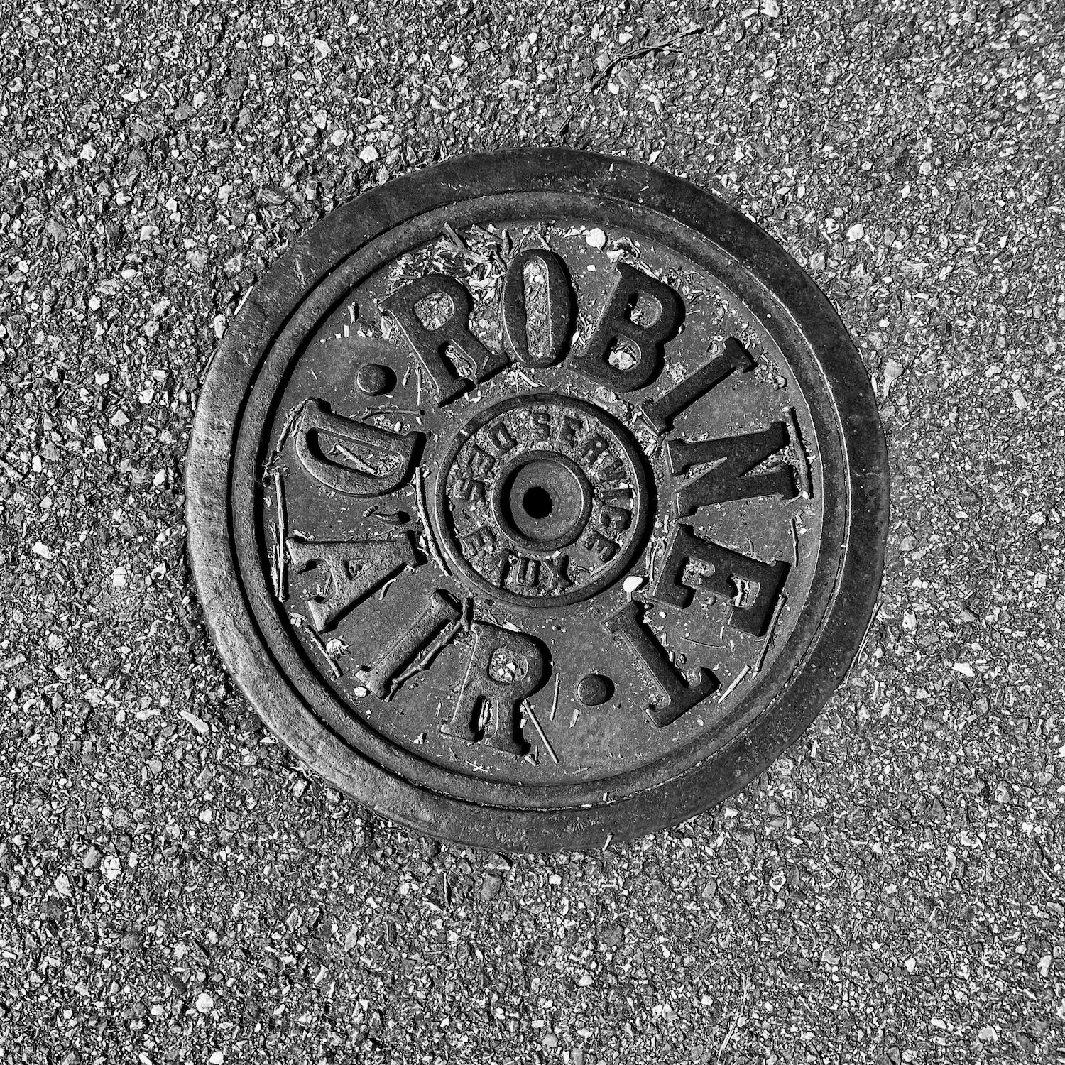 black and white image of a utility cover