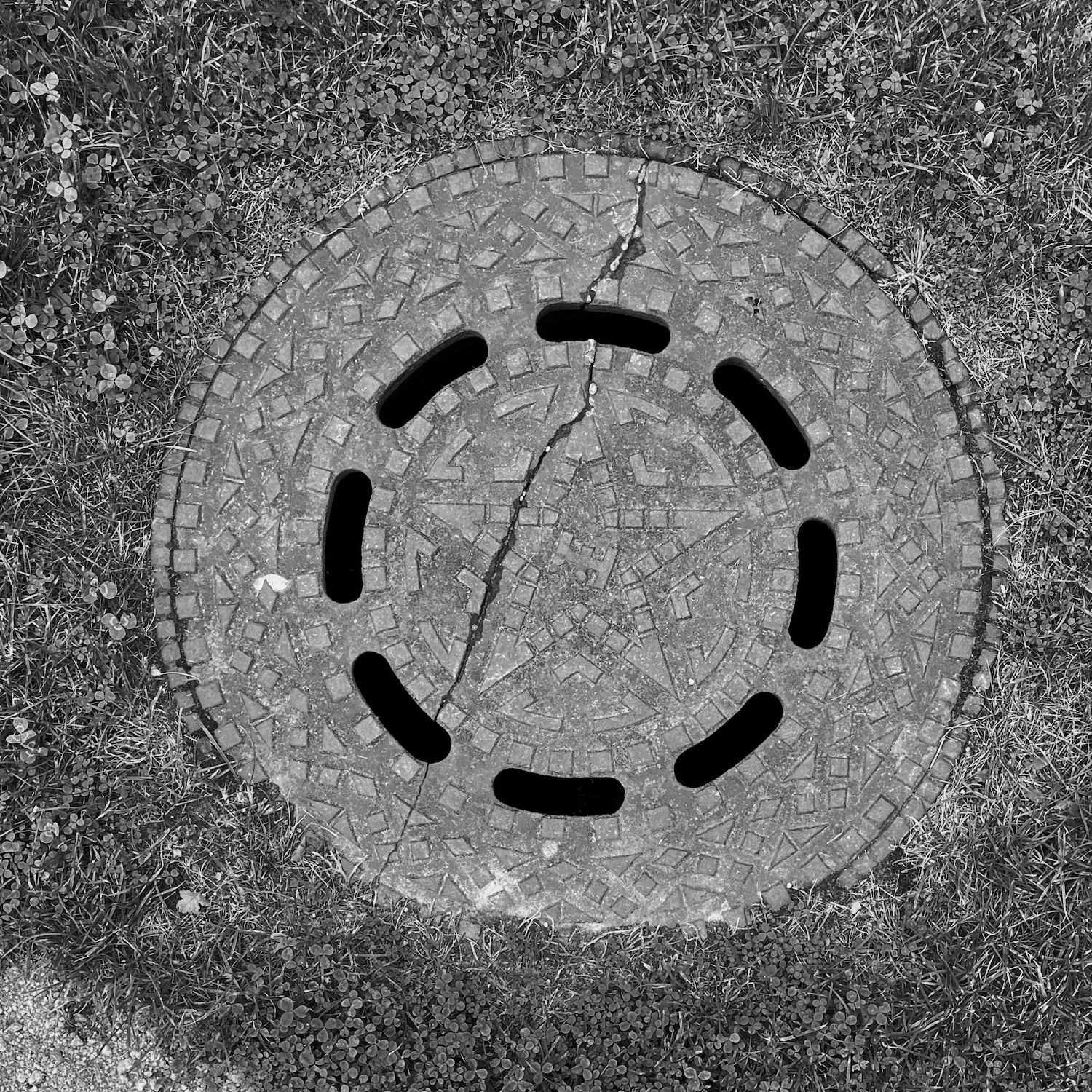 black and white image of a utility cover