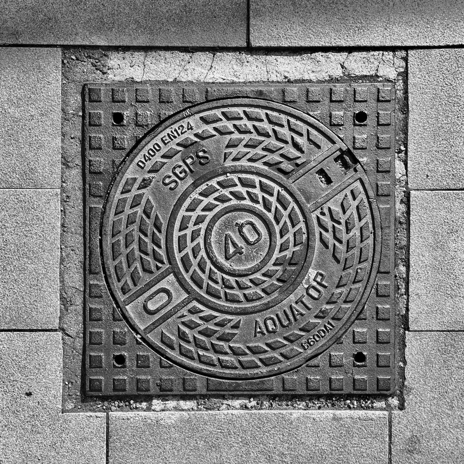 black and white image of a utility cover