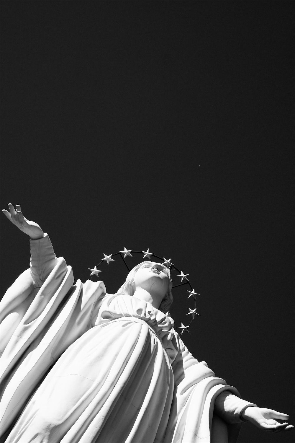 virgin mary statue at the top of cerro san cristobal in black and white