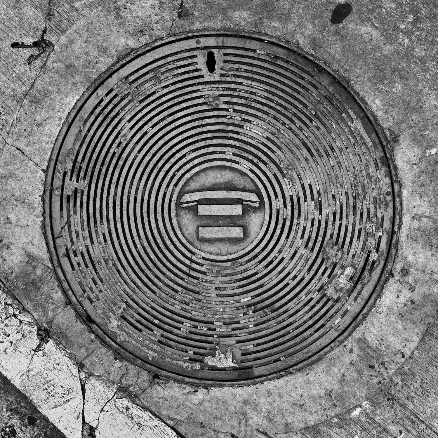 black and white image of a utility cover