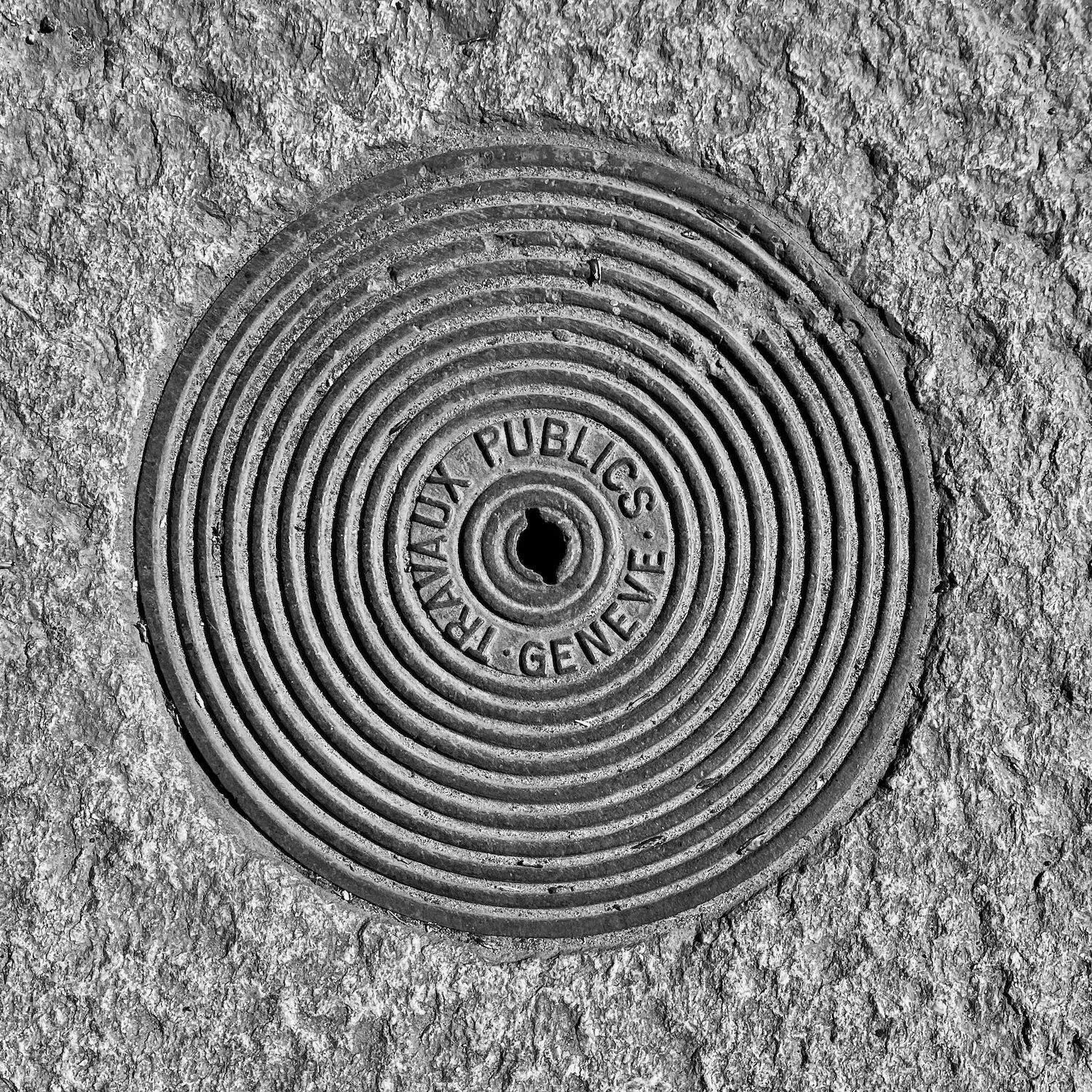 black and white image of a utility cover