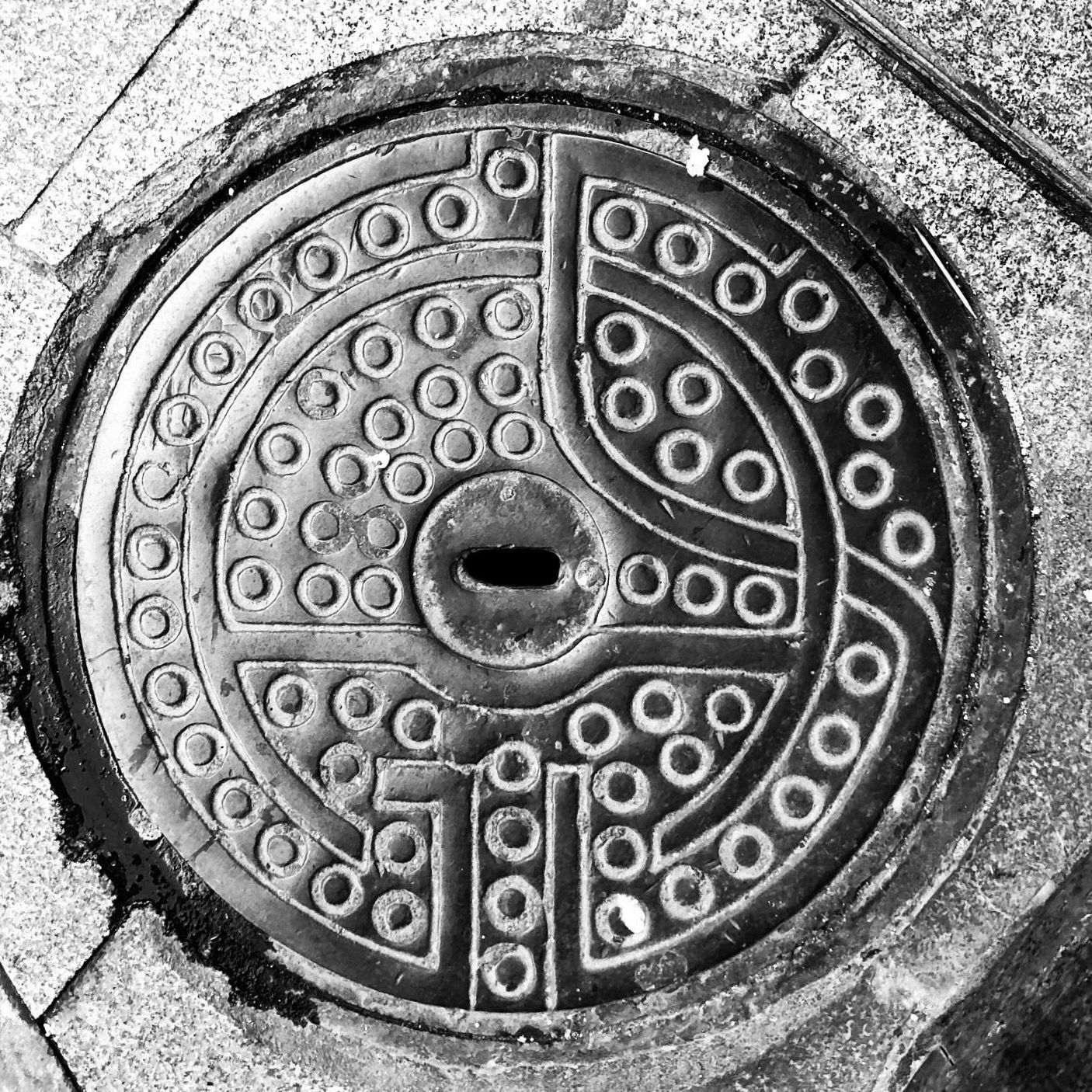 black and white image of a utility cover