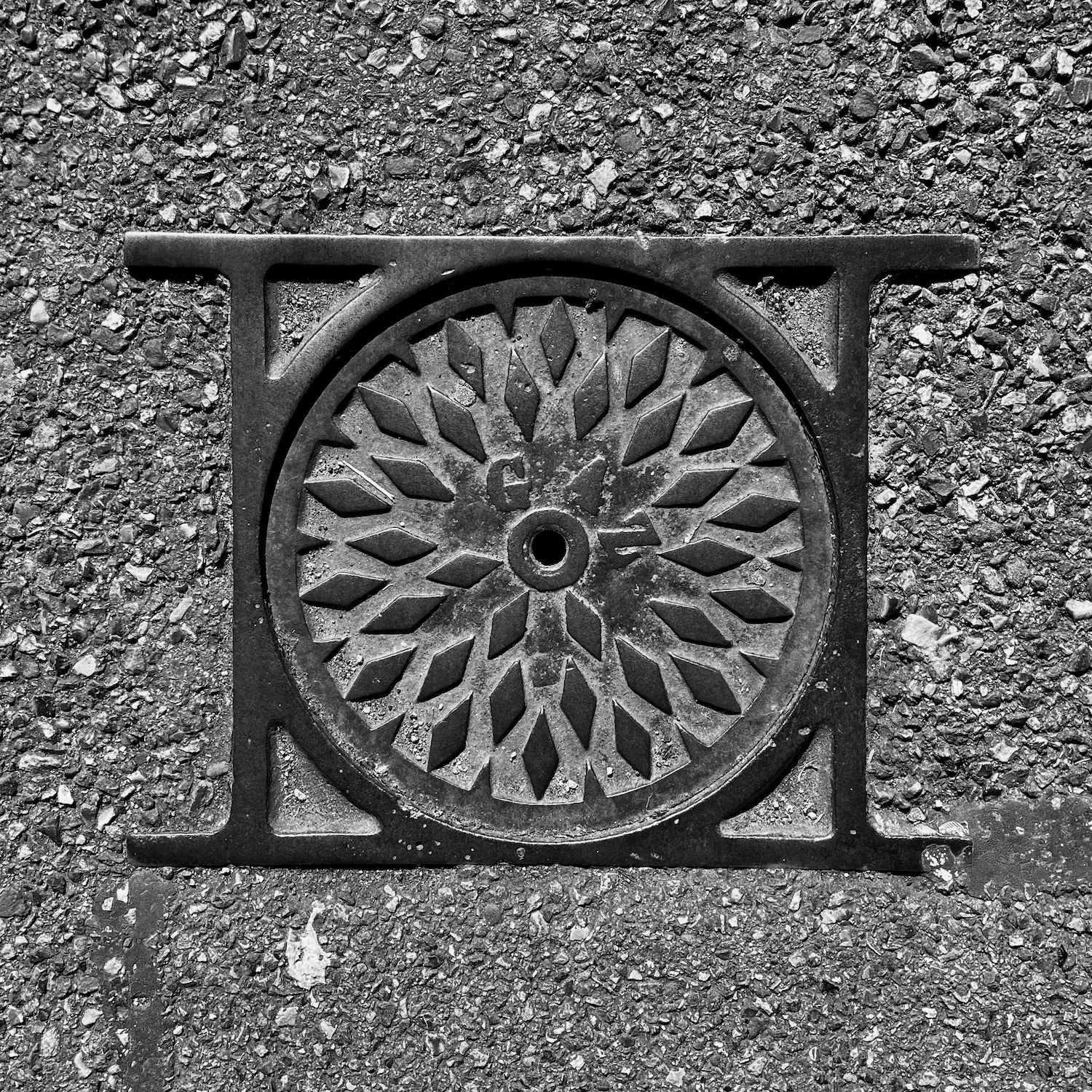 black and white image of a utility cover