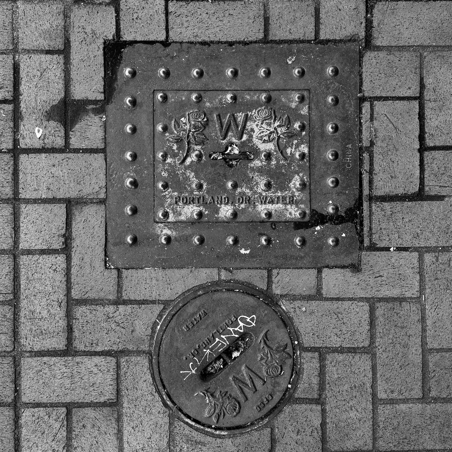 black and white image of a utility cover