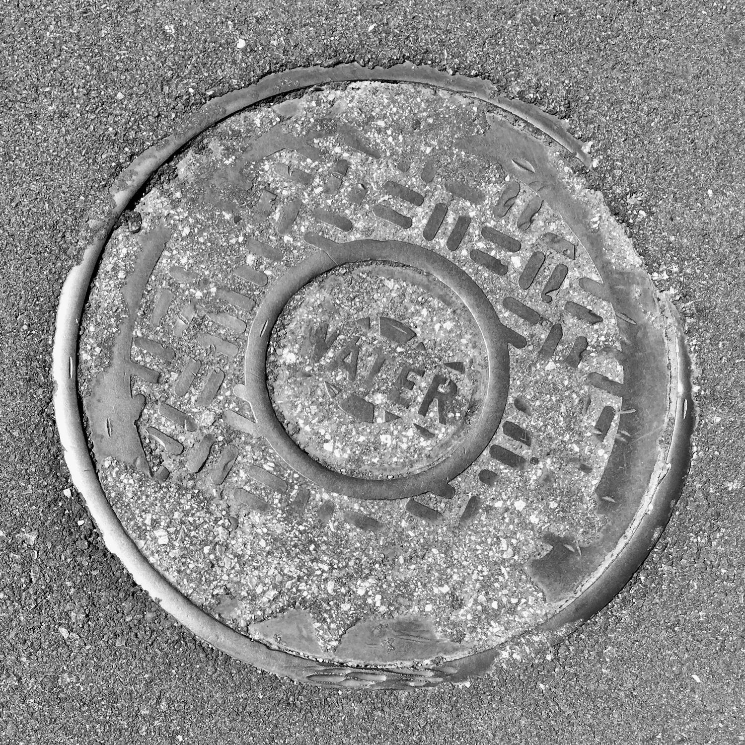 black and white image of a utility cover