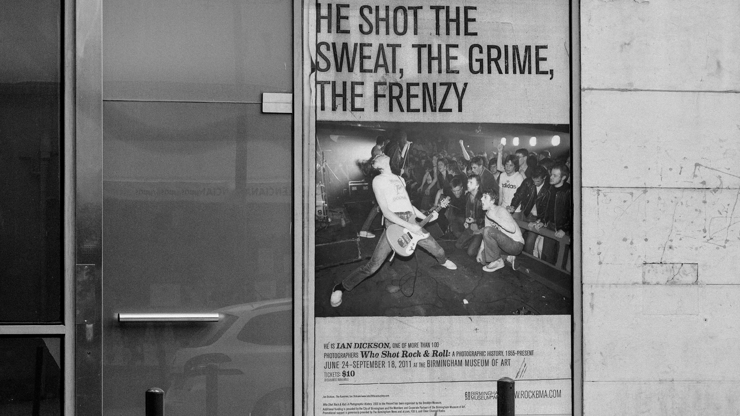 black and white image of a poster in the window of a storefront