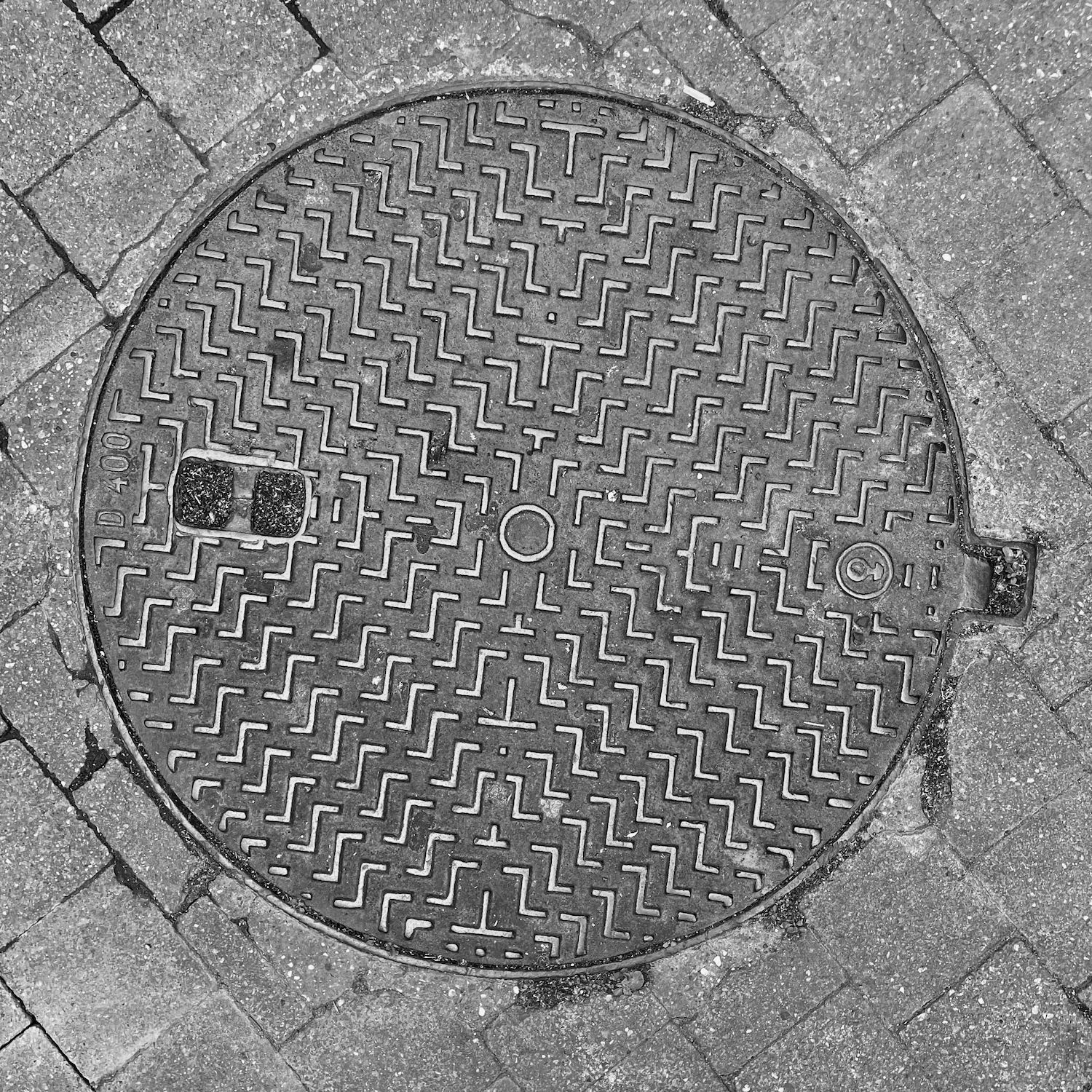 black and white image of a utility cover