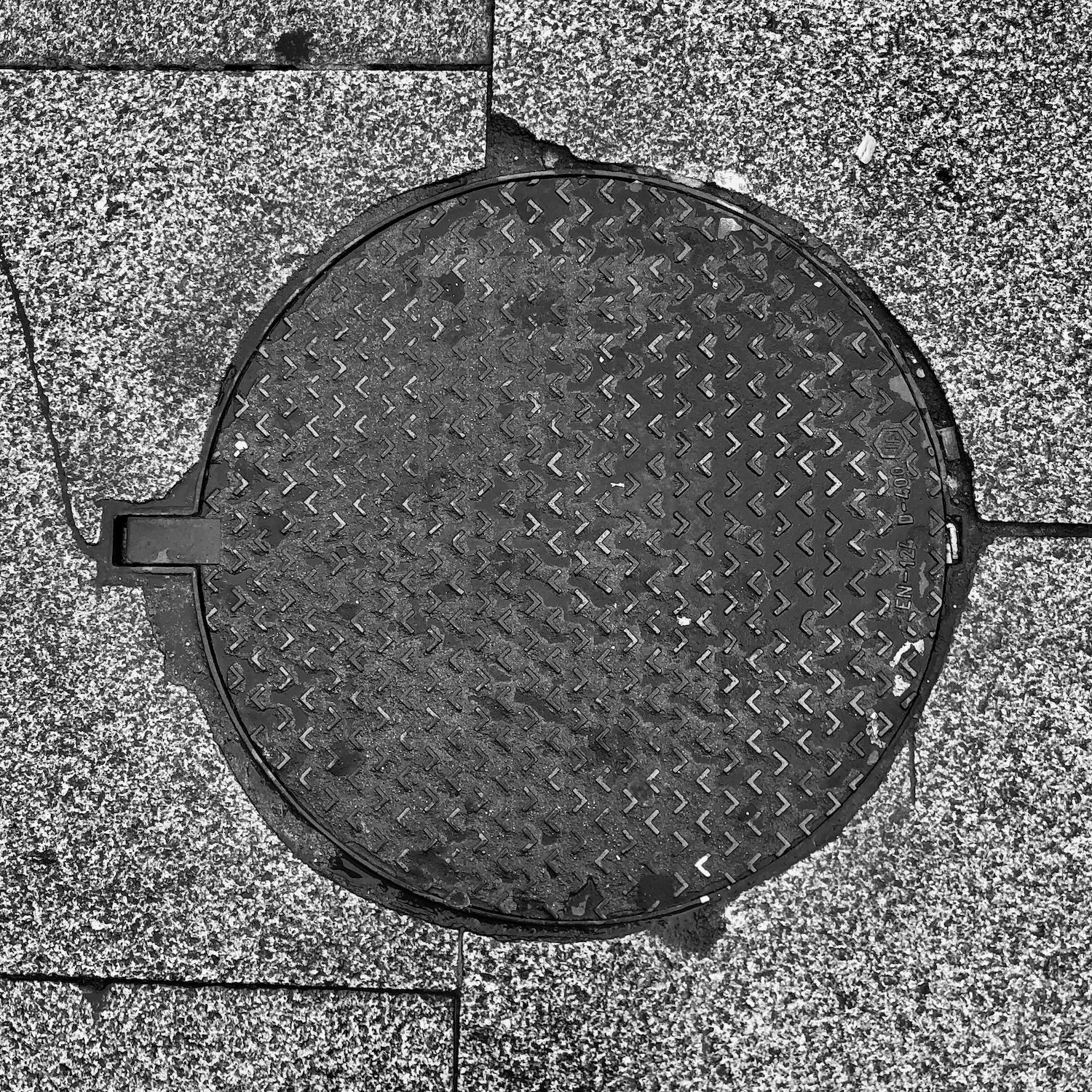 black and white image of a utility cover