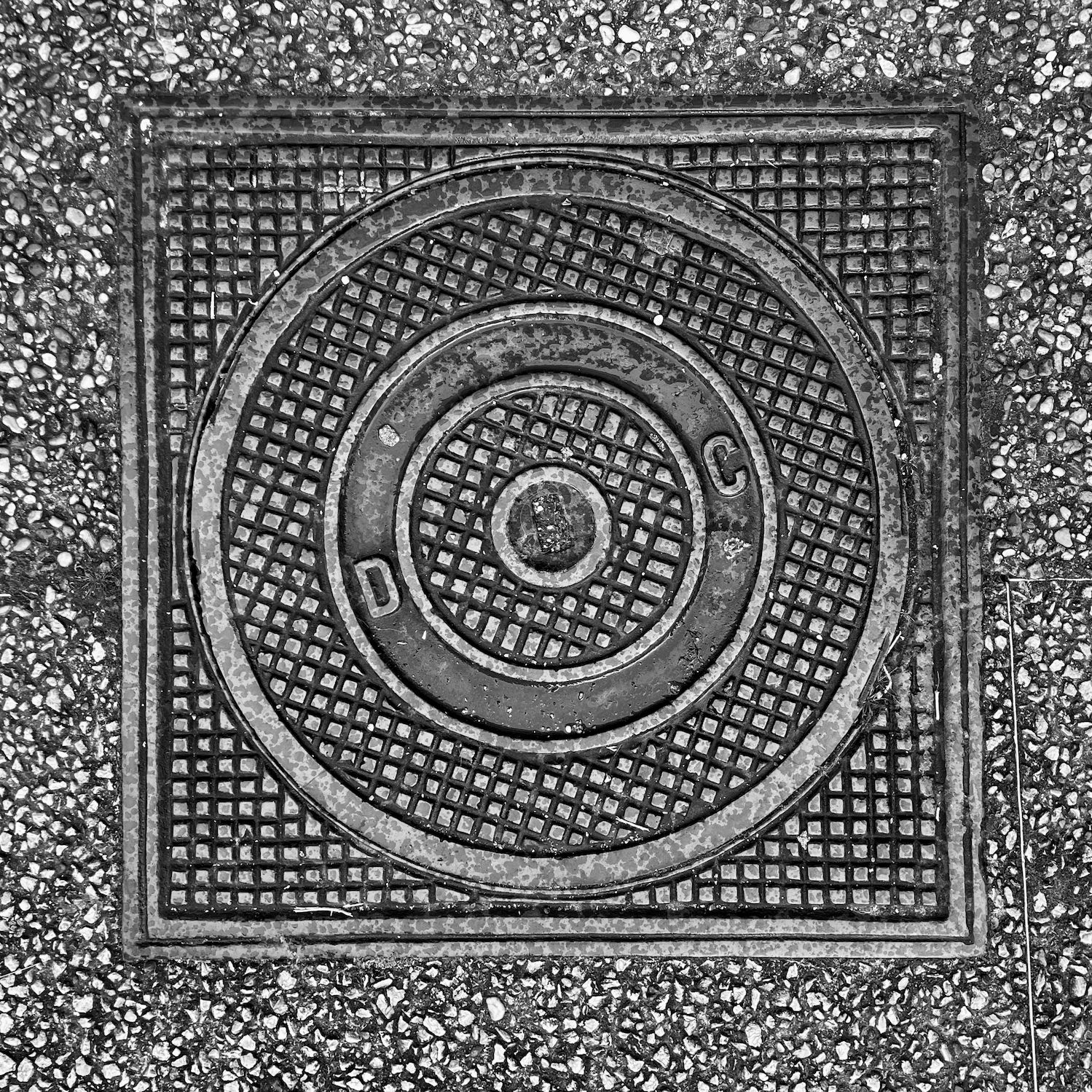black and white image of a utility cover