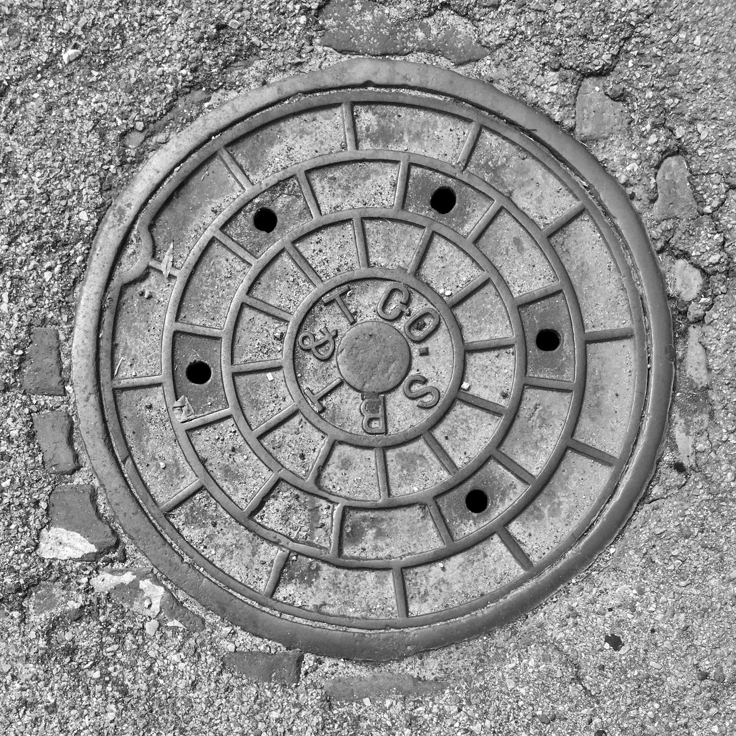 black and white image of a utility cover