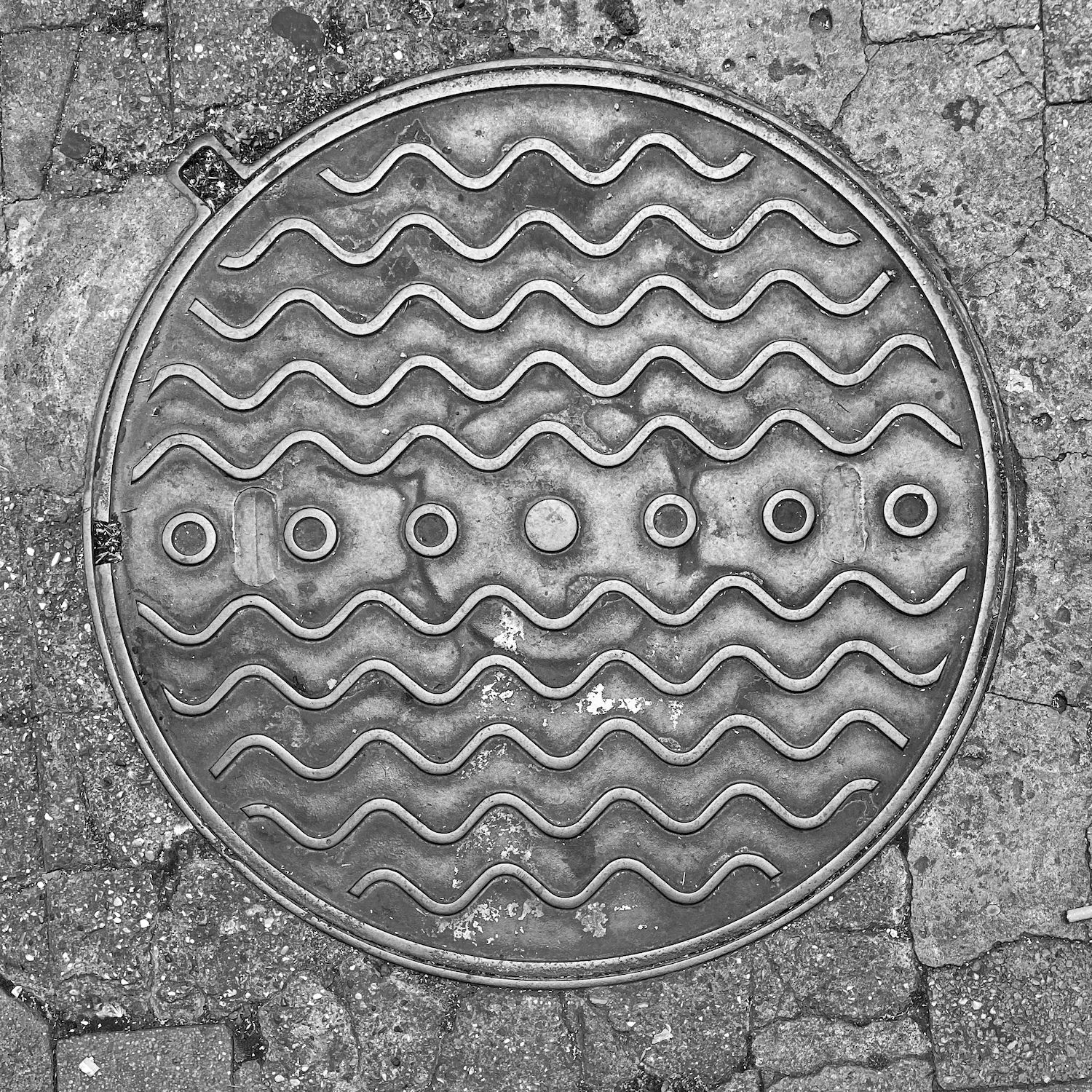 black and white image of a utility cover