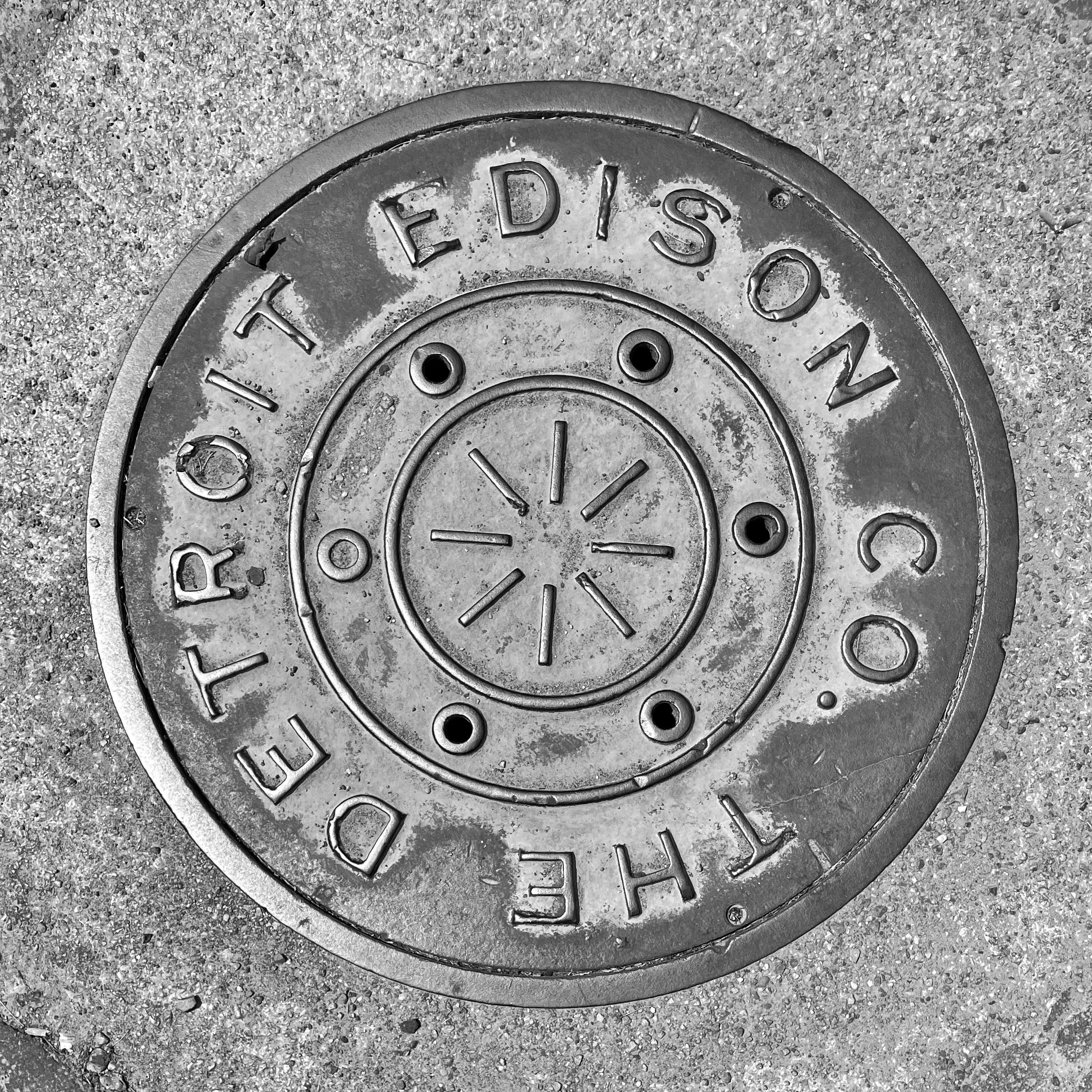 black and white image of a utility cover