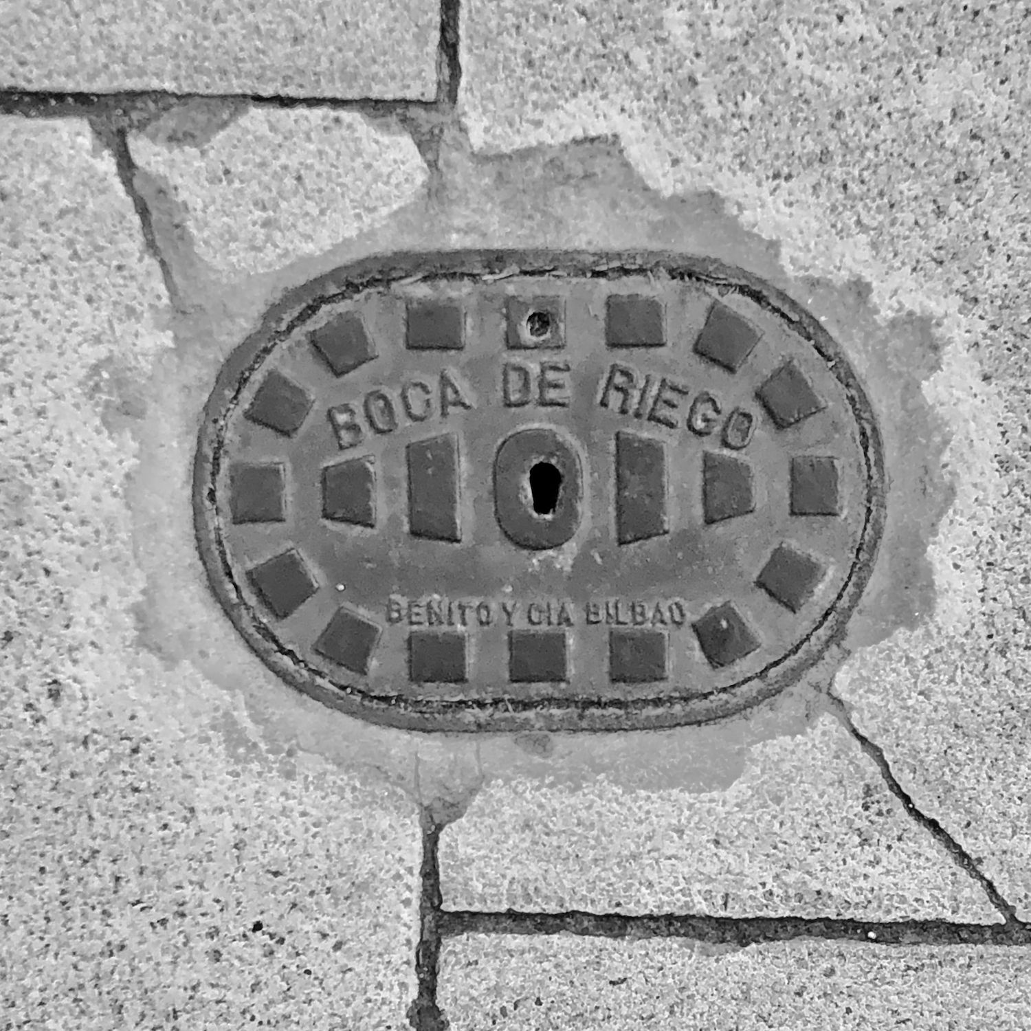 black and white image of a utility cover