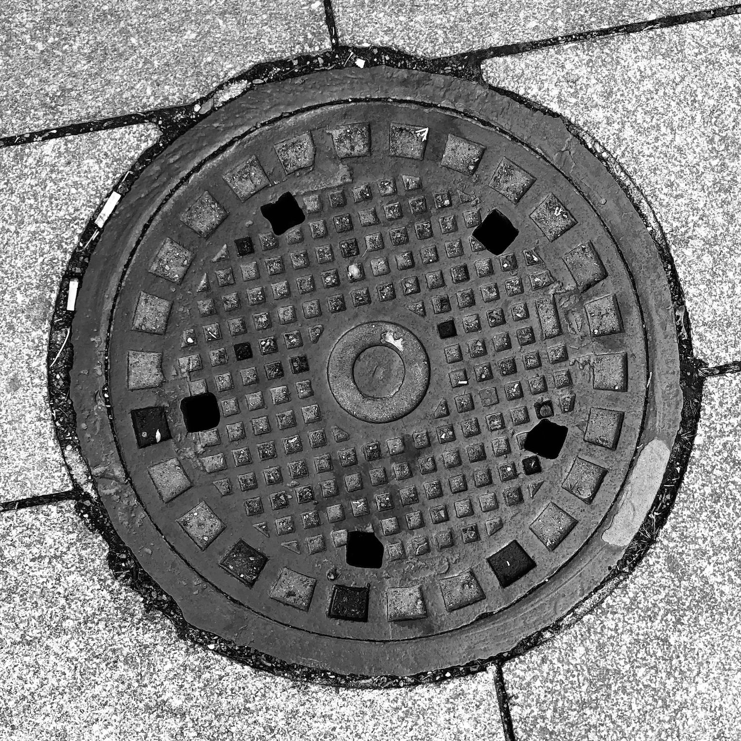 black and white image of a utility cover
