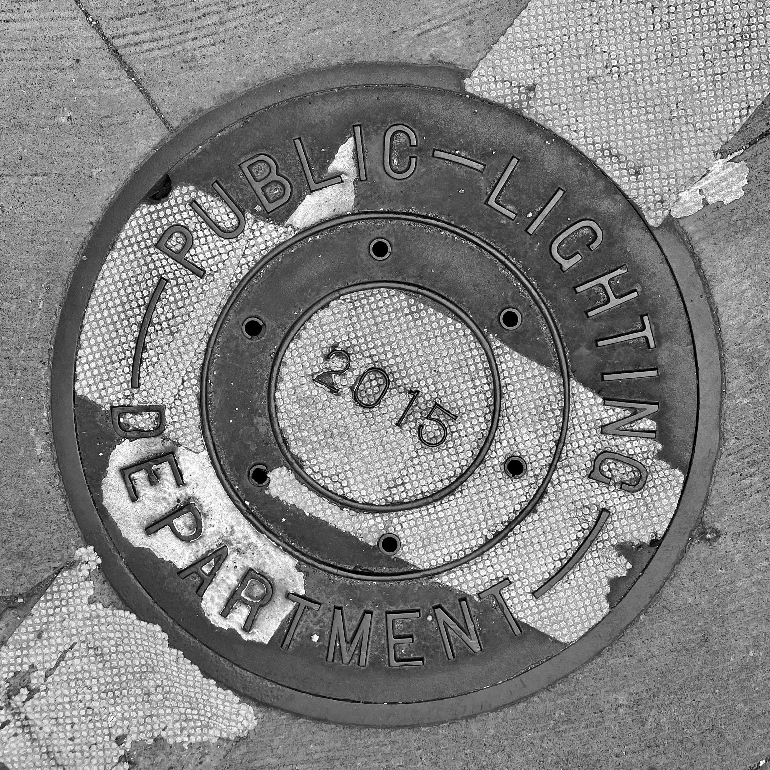 black and white image of a utility cover