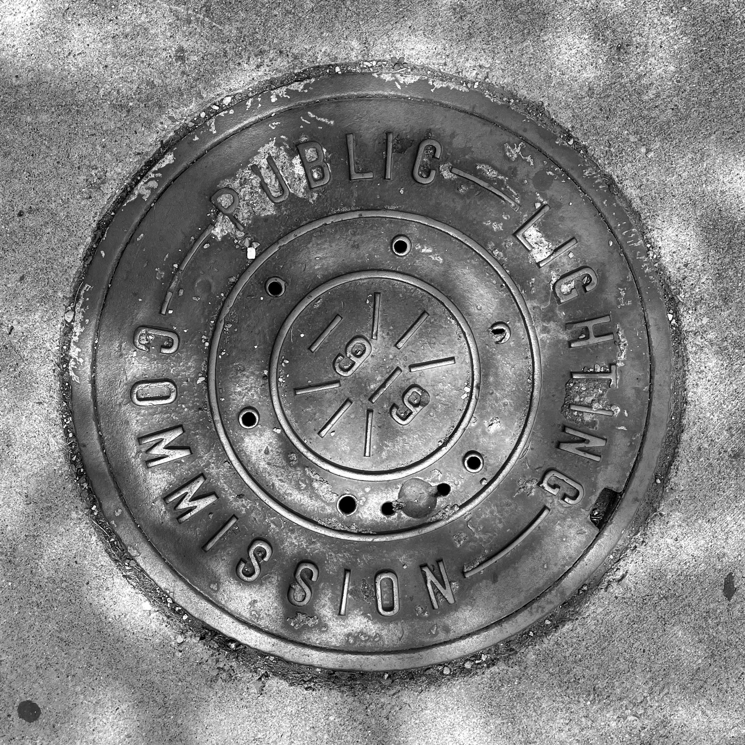 black and white image of a utility cover