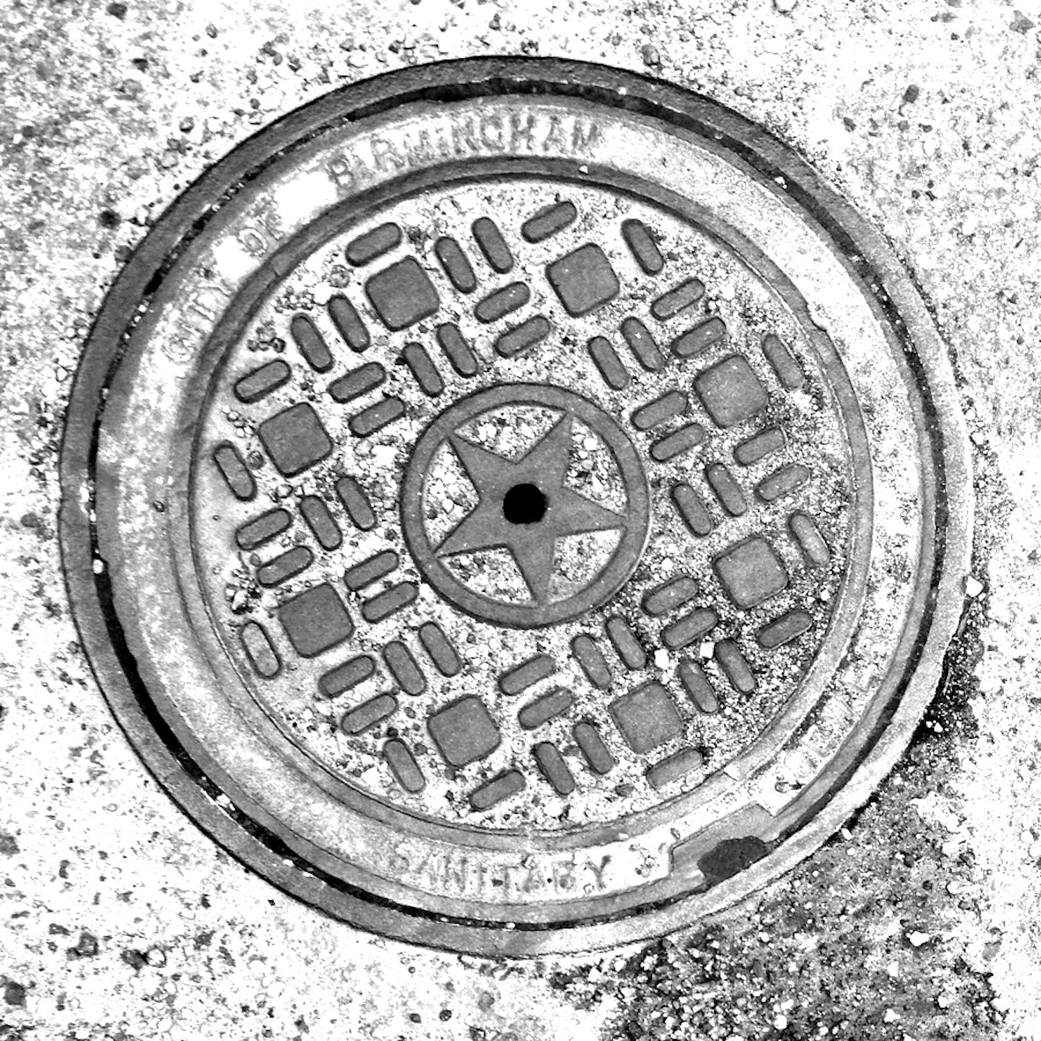 black and white image of a utility cover